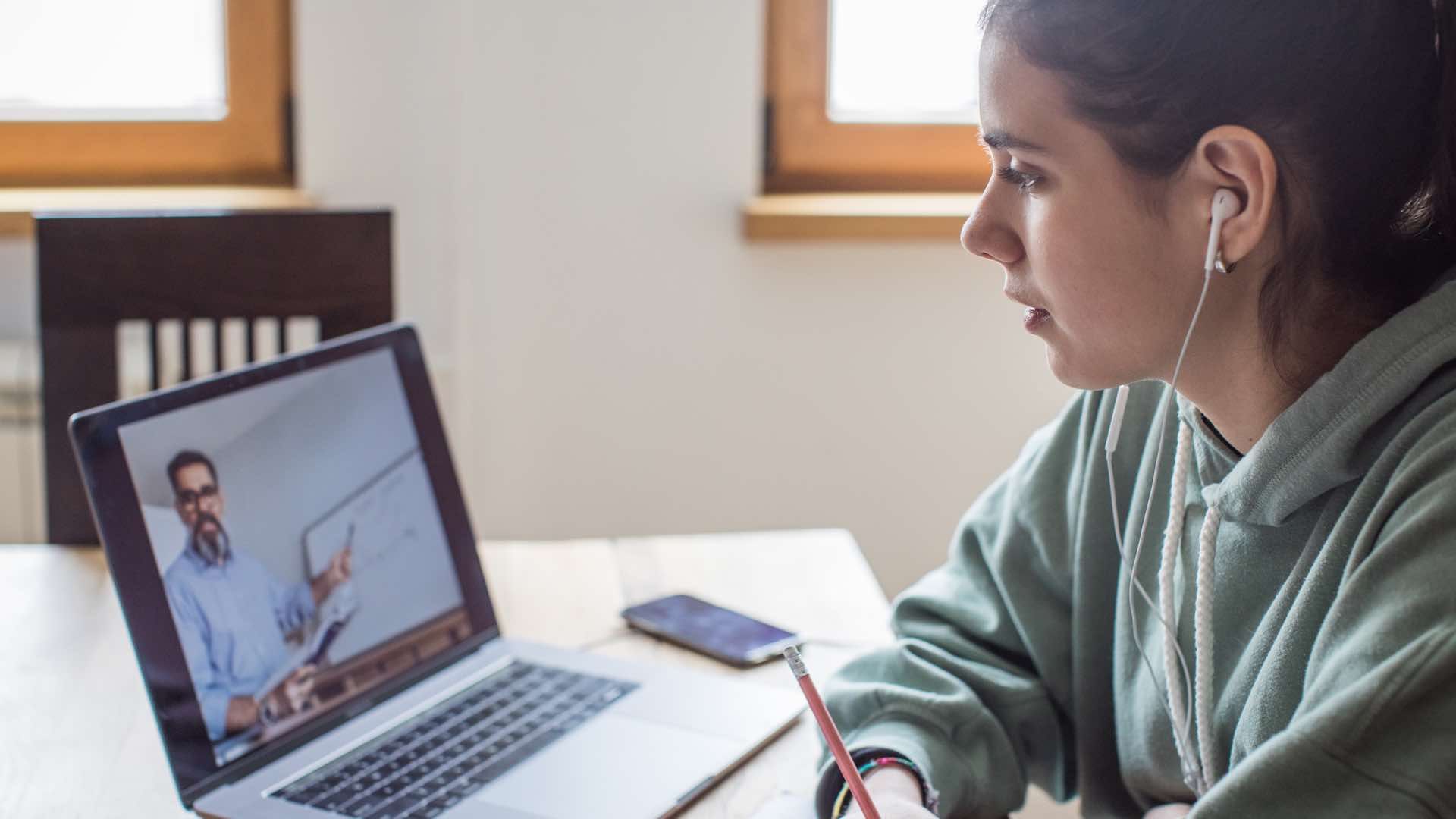 Woman watches and listens to a lesson online.