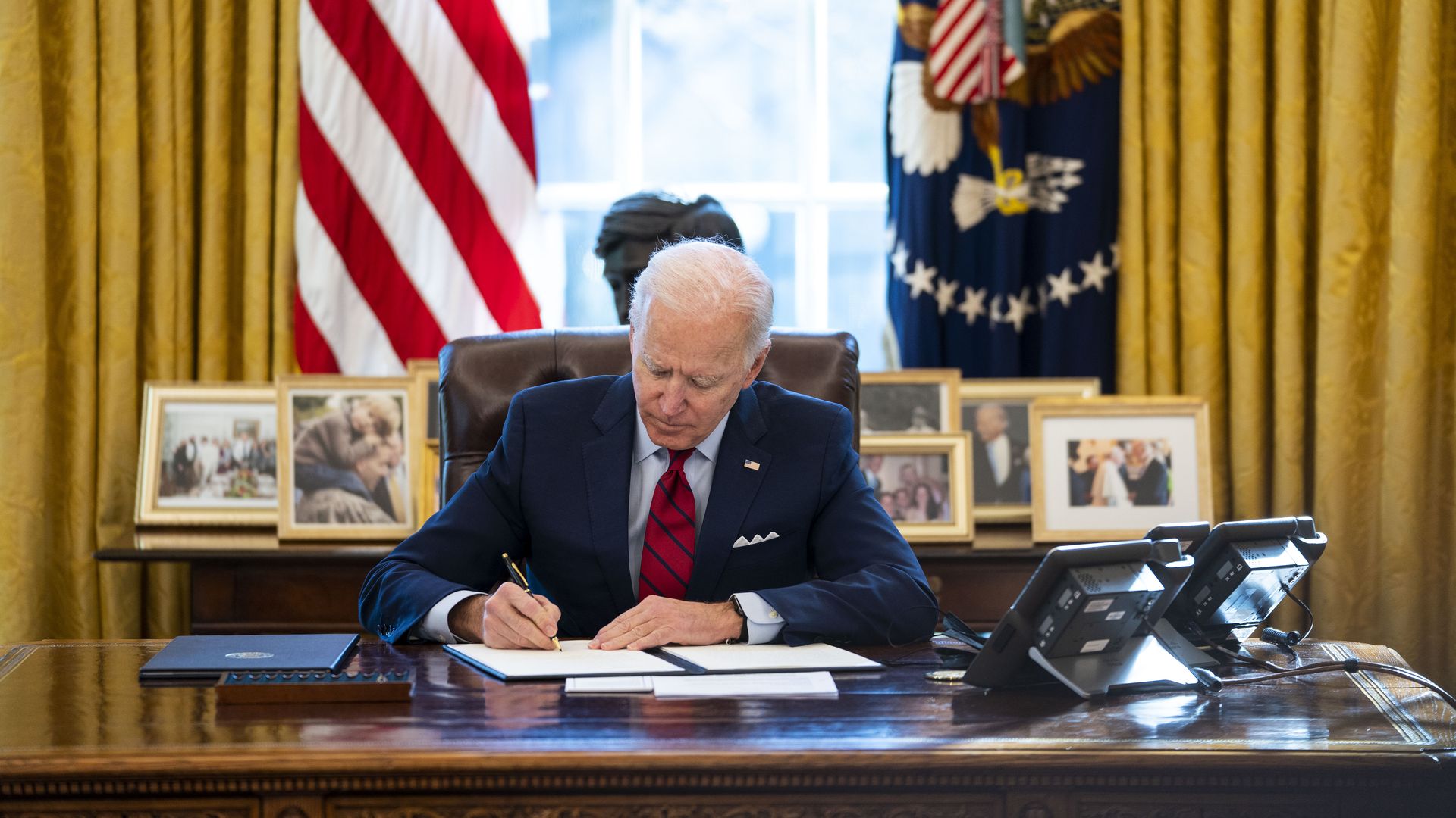 Picture of Joe Biden signing an executive order in the Oval Office