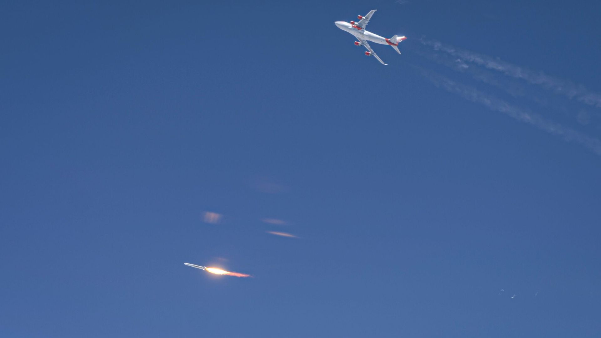 A plane flying above a rocket launching to space