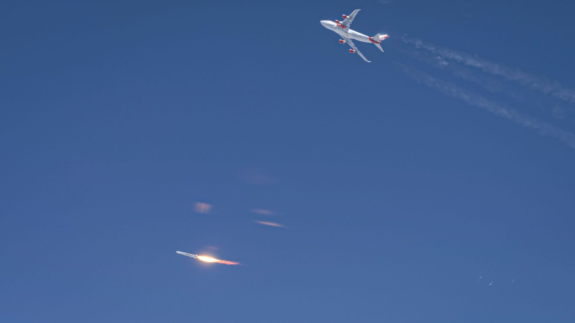 A plane flying above a rocket launching to space