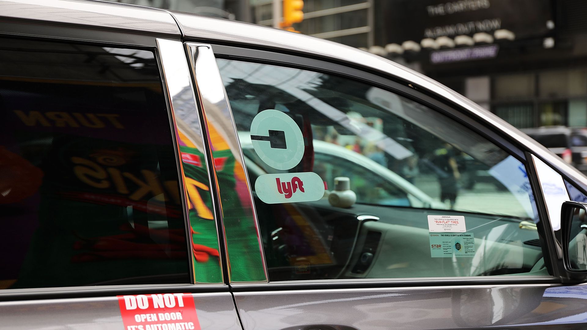 Photo of car with Uber and Lyft stickers in NYC. 