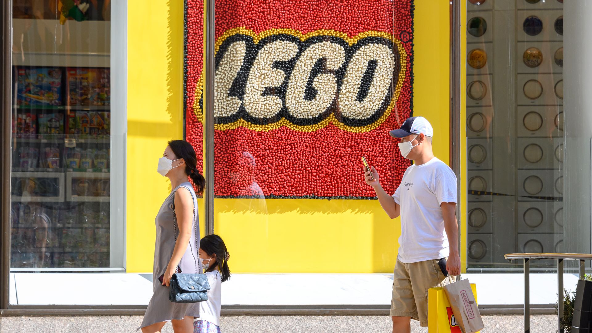 A photo of people in masks outside the Lego store. 