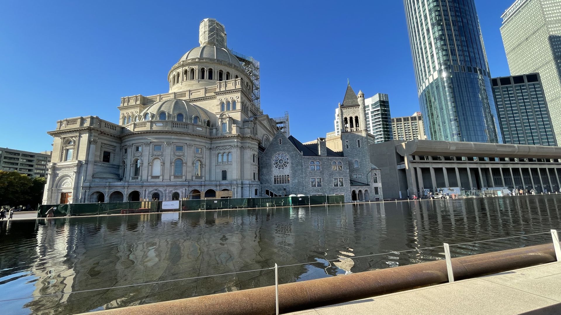 The Christian Science Center stands on the plaza near a reflecting pool.