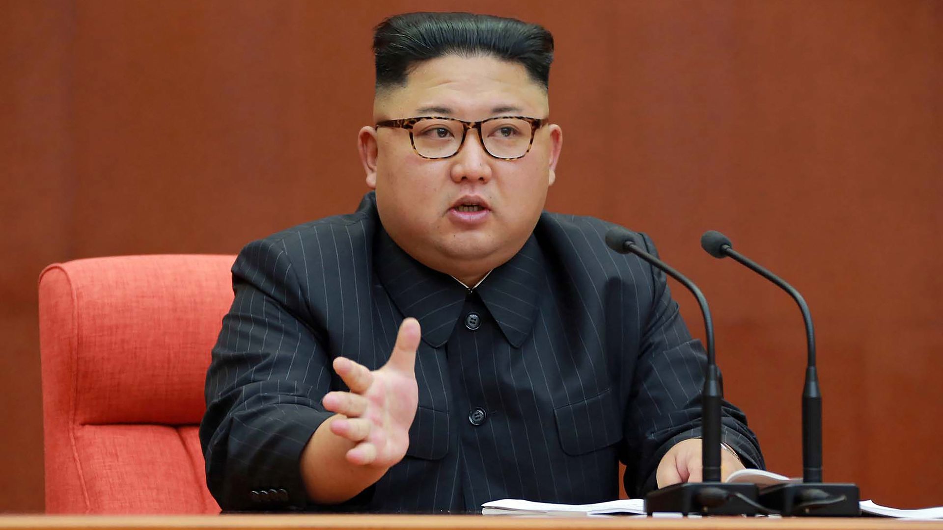 Kim Jong-un seated giving speech