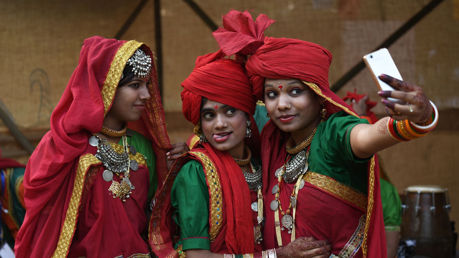 Indian women pose for a selfie with their smartphone