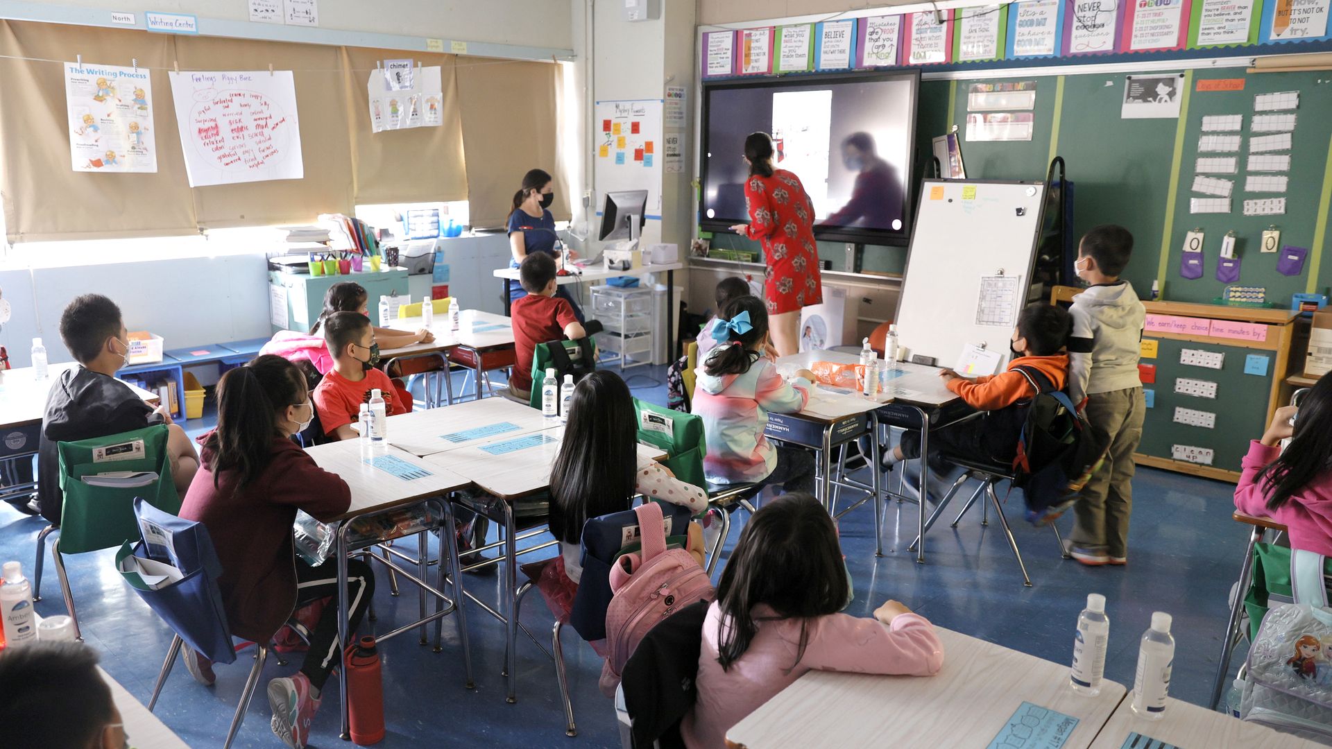 Co-teachers at Yung Wing School P.S. 124 Marisa Wieze and Caitlin Kenny give a lesson to their masked students in their classroom on September 27, 2021 in New York City.
