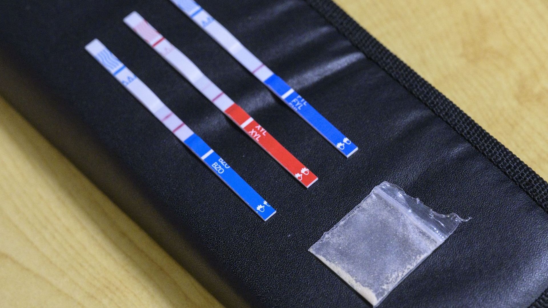 Tests strips, used to detect the presence of fentanyl and xylazine in different kinds of drugs, such as cocaine, methamphetamine, and heroin, lay next to a bag of heroin .