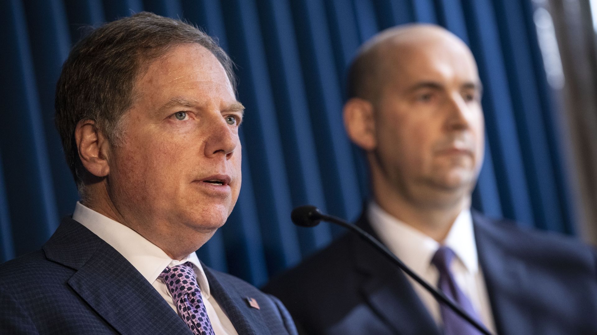 Geoffrey stands in a suit