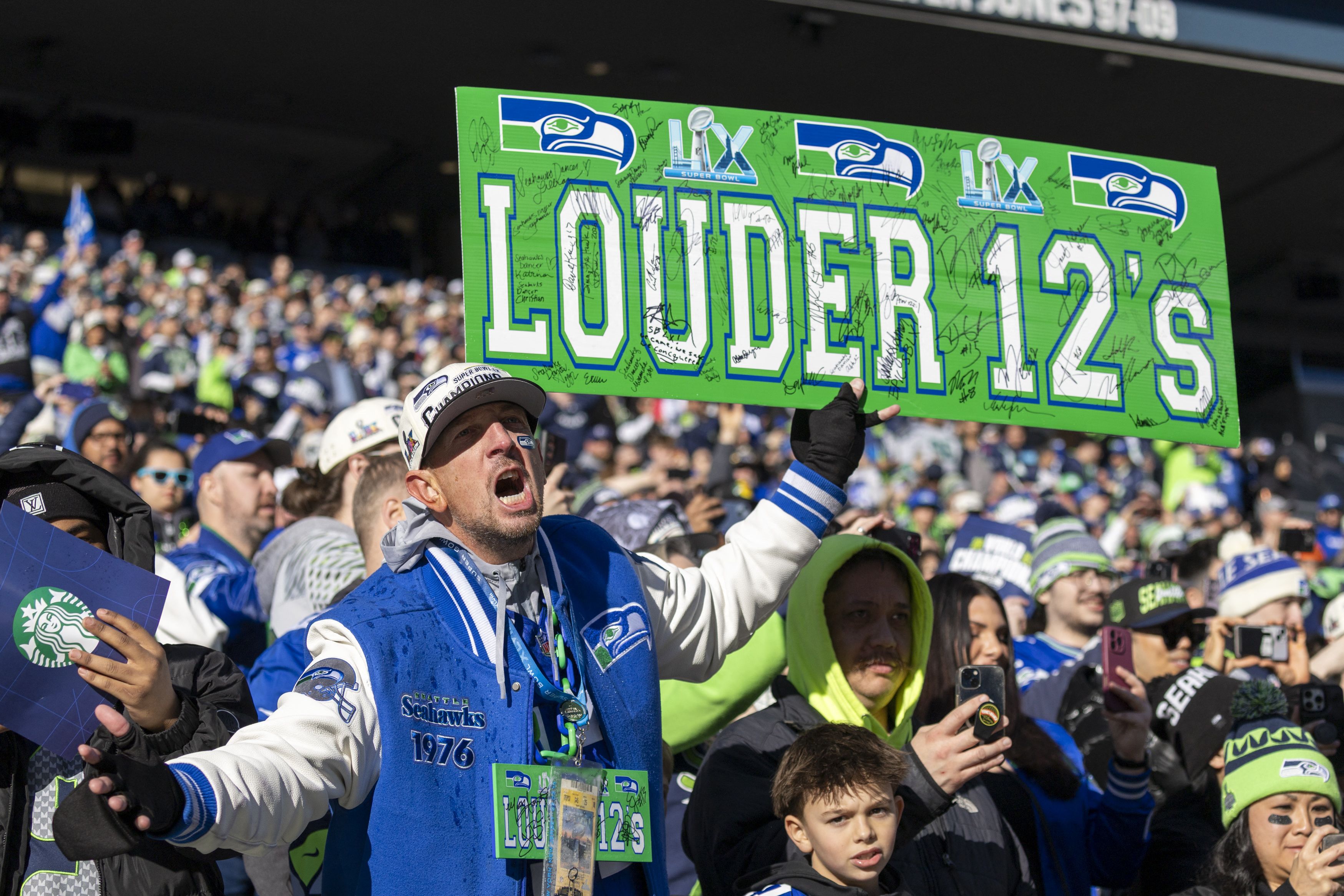 A screaming crowd of Hawks fan with a "Louder 12's" sign in view.