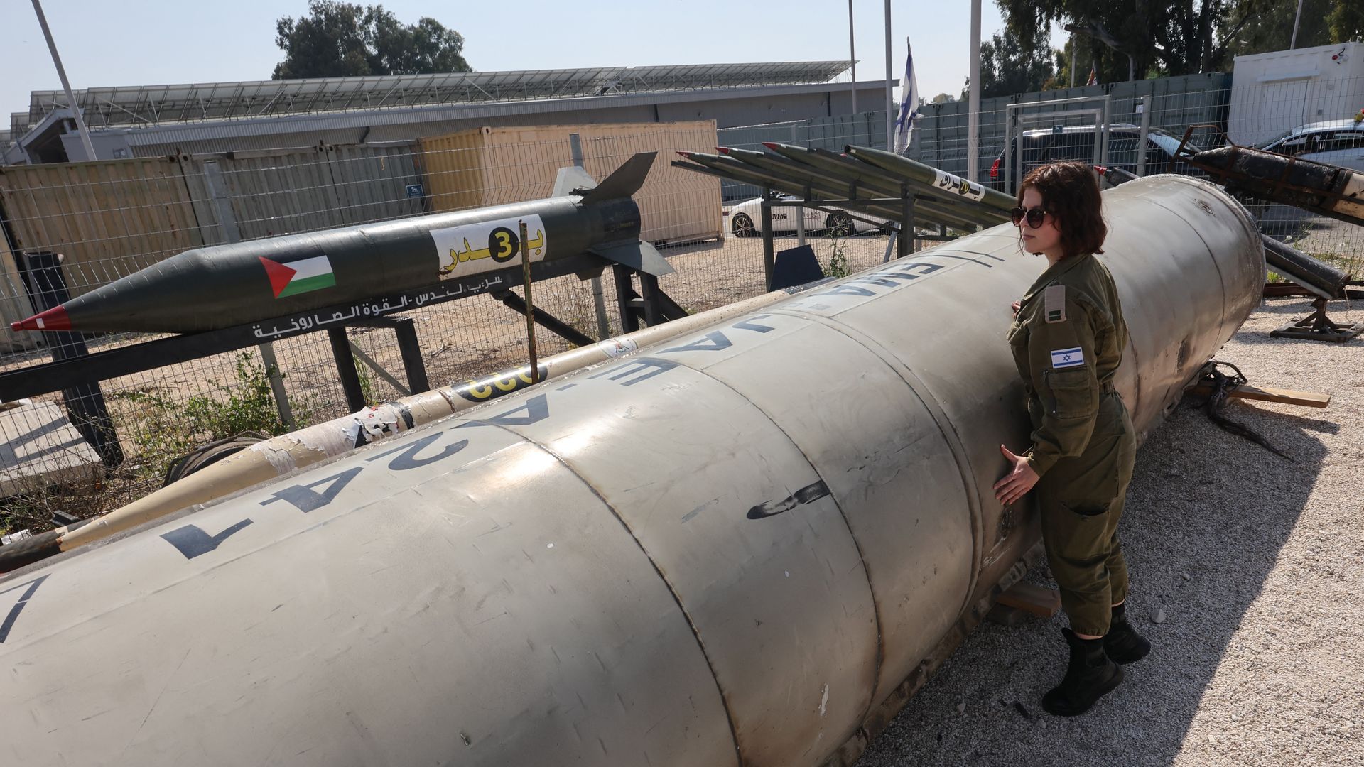 A member of the Israeli military stands next to an Iranian ballistic missile that fell in Israel.