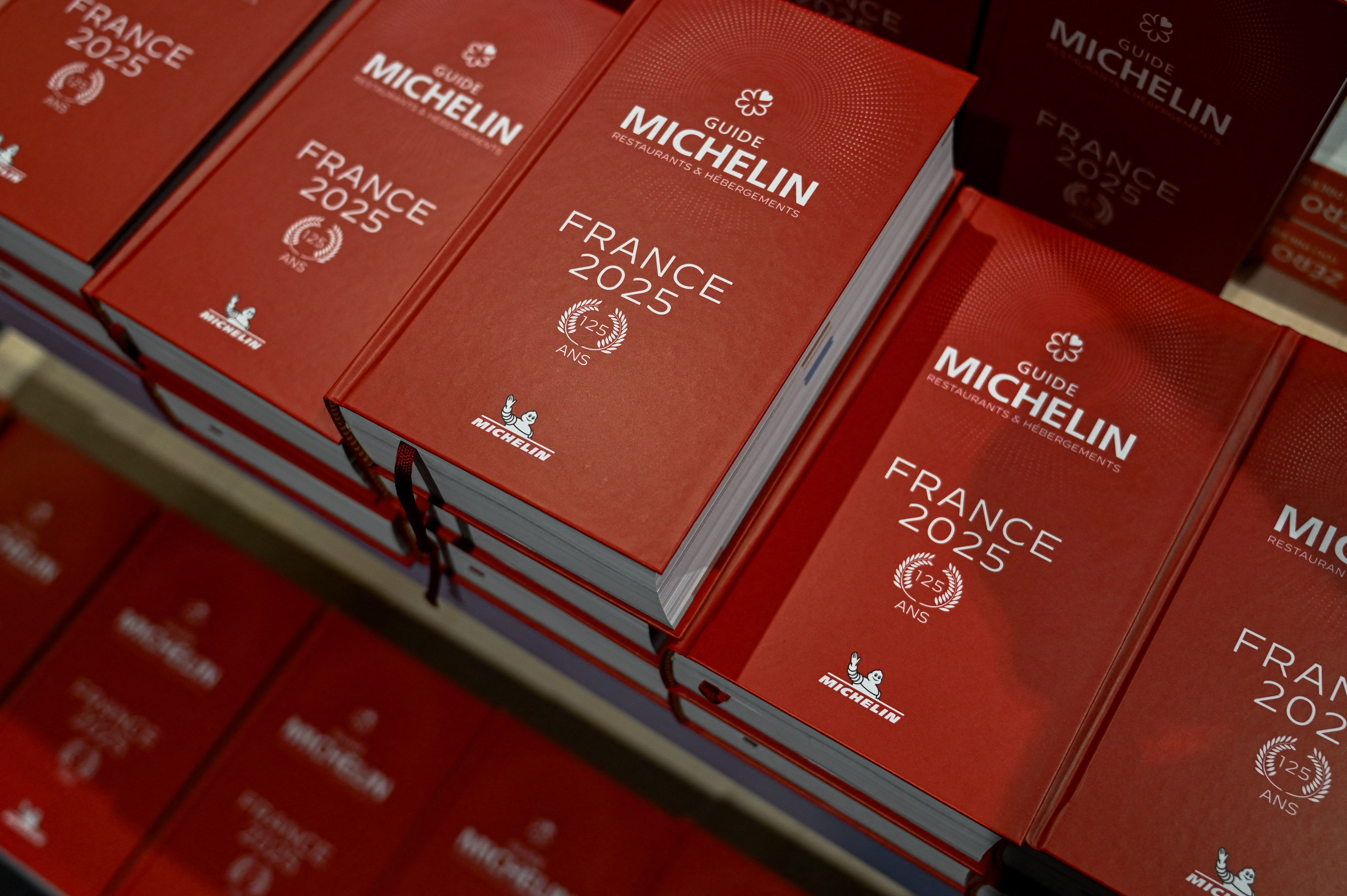 A stack of red books that say "Guide Michelin: France 2025."