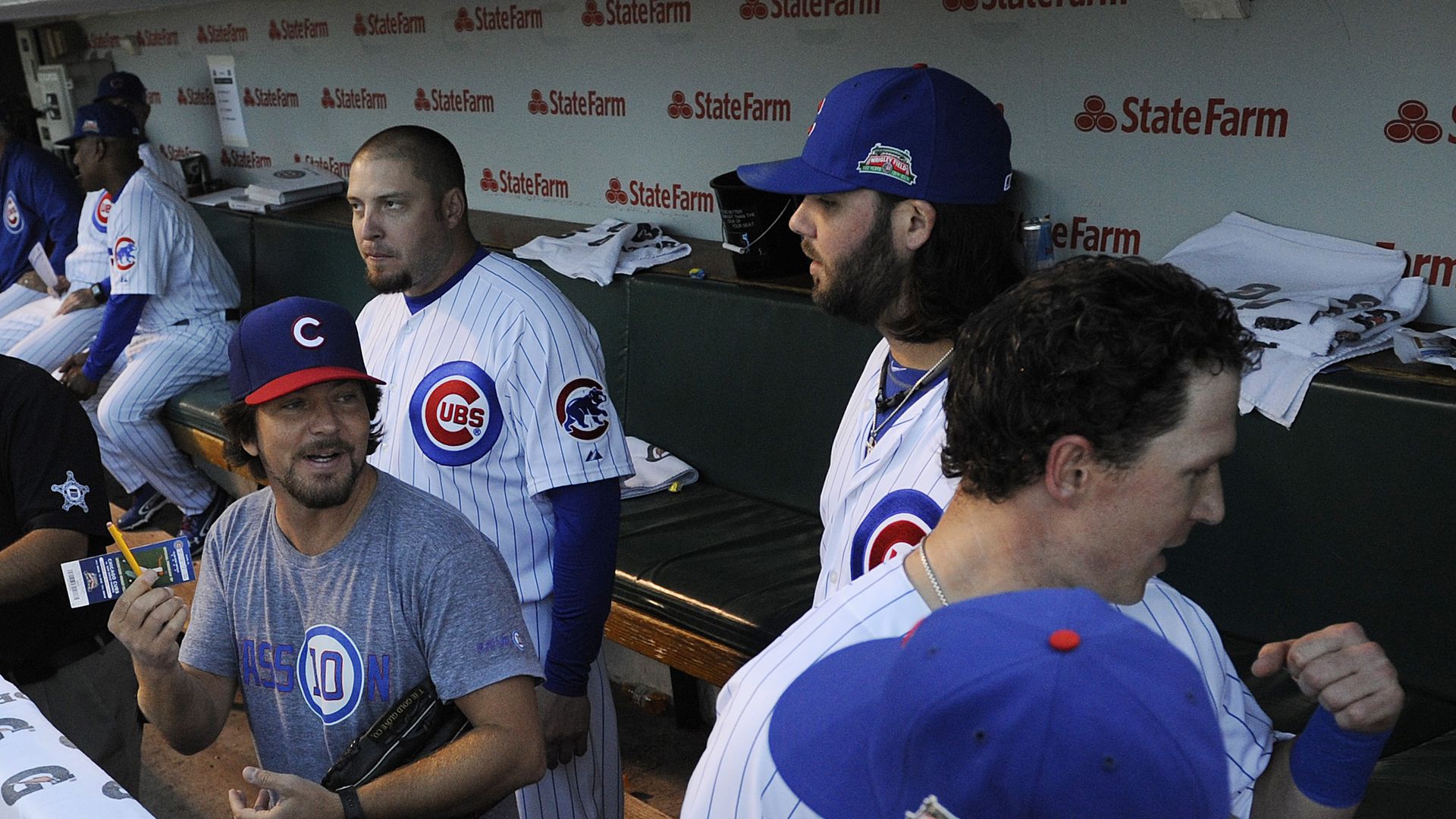Eddie Vedder wearing a Cubs hat in the Cubs dugout before a game