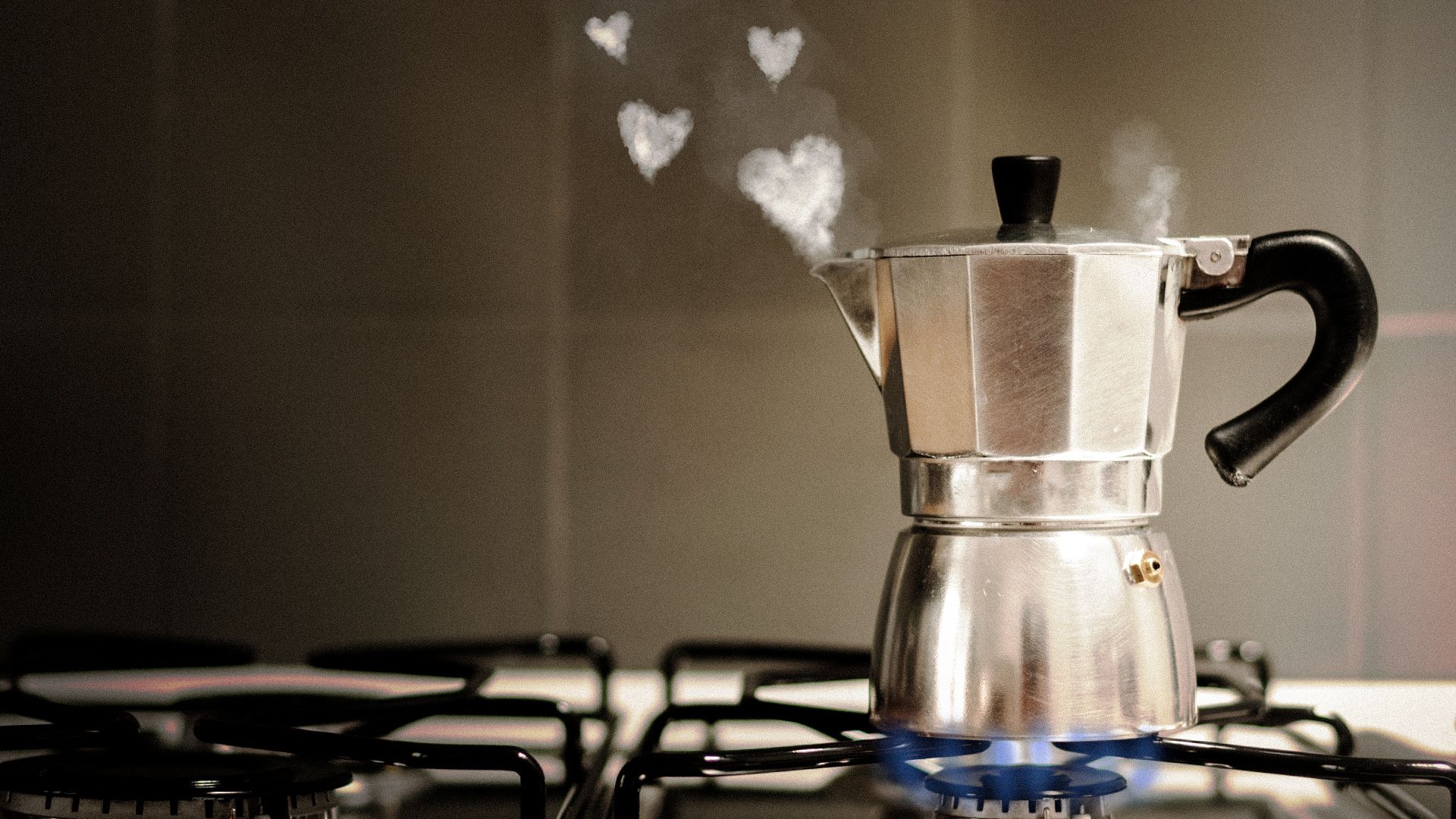 Illustration of a Moka pot being heated on a stove, with steam coming out in the shape of small hearts.