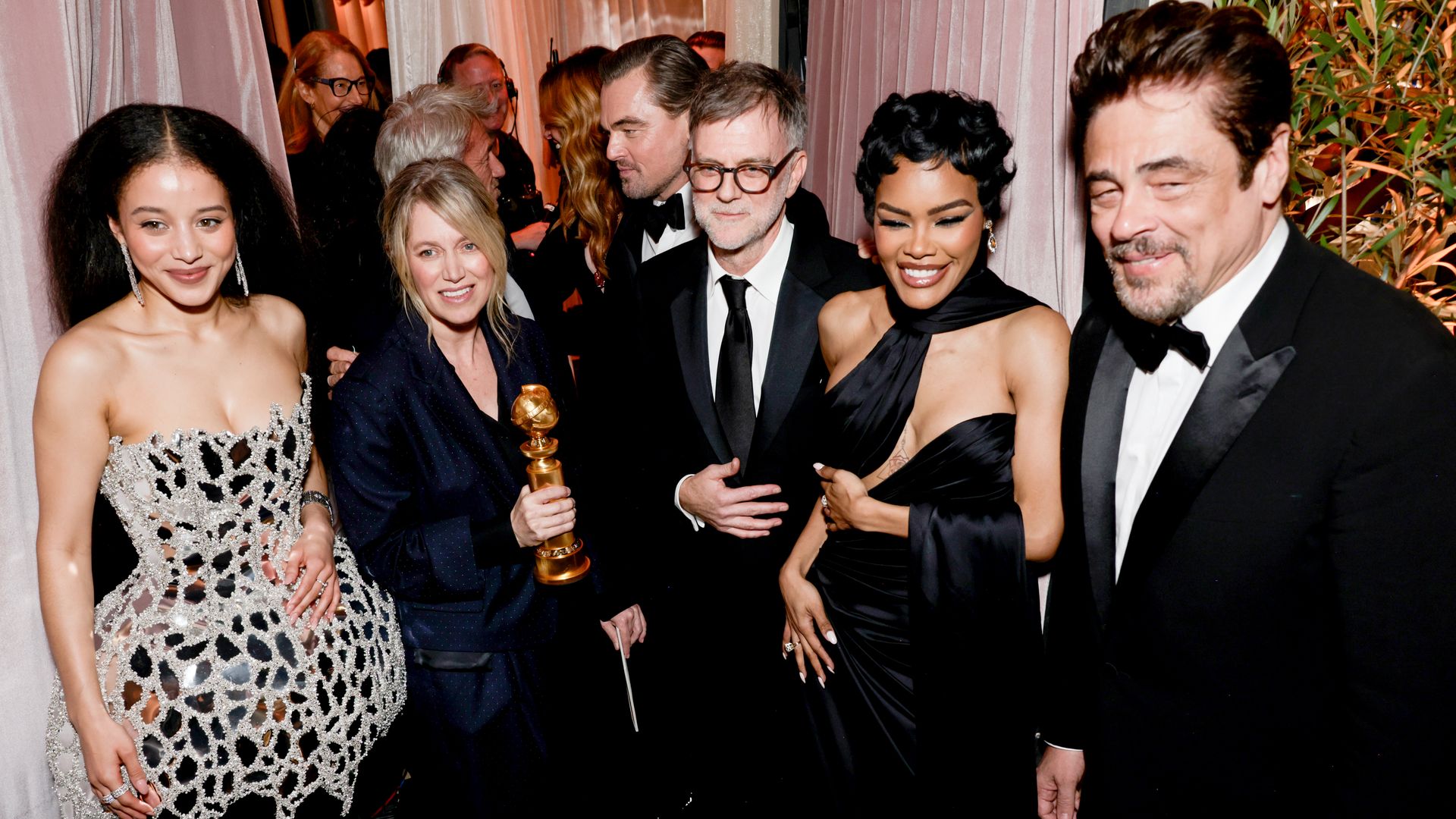 The cast of One Battle After Another pictured attending the Golden Globes in January — Chase Infiniti, Sara Murphy, Leonardo DiCaprio, Paul Thomas Anderson, Teyana Taylor, and Benicio del Toro