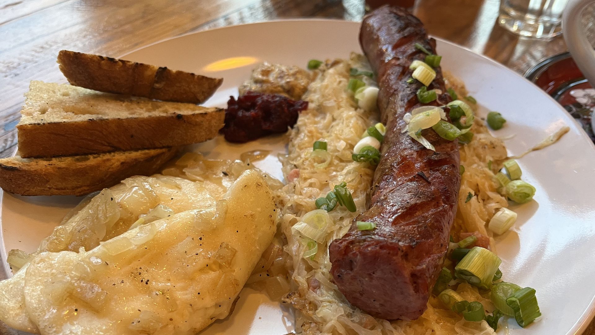 Plate with kielbasa on sauerkraut, pierogis and toast