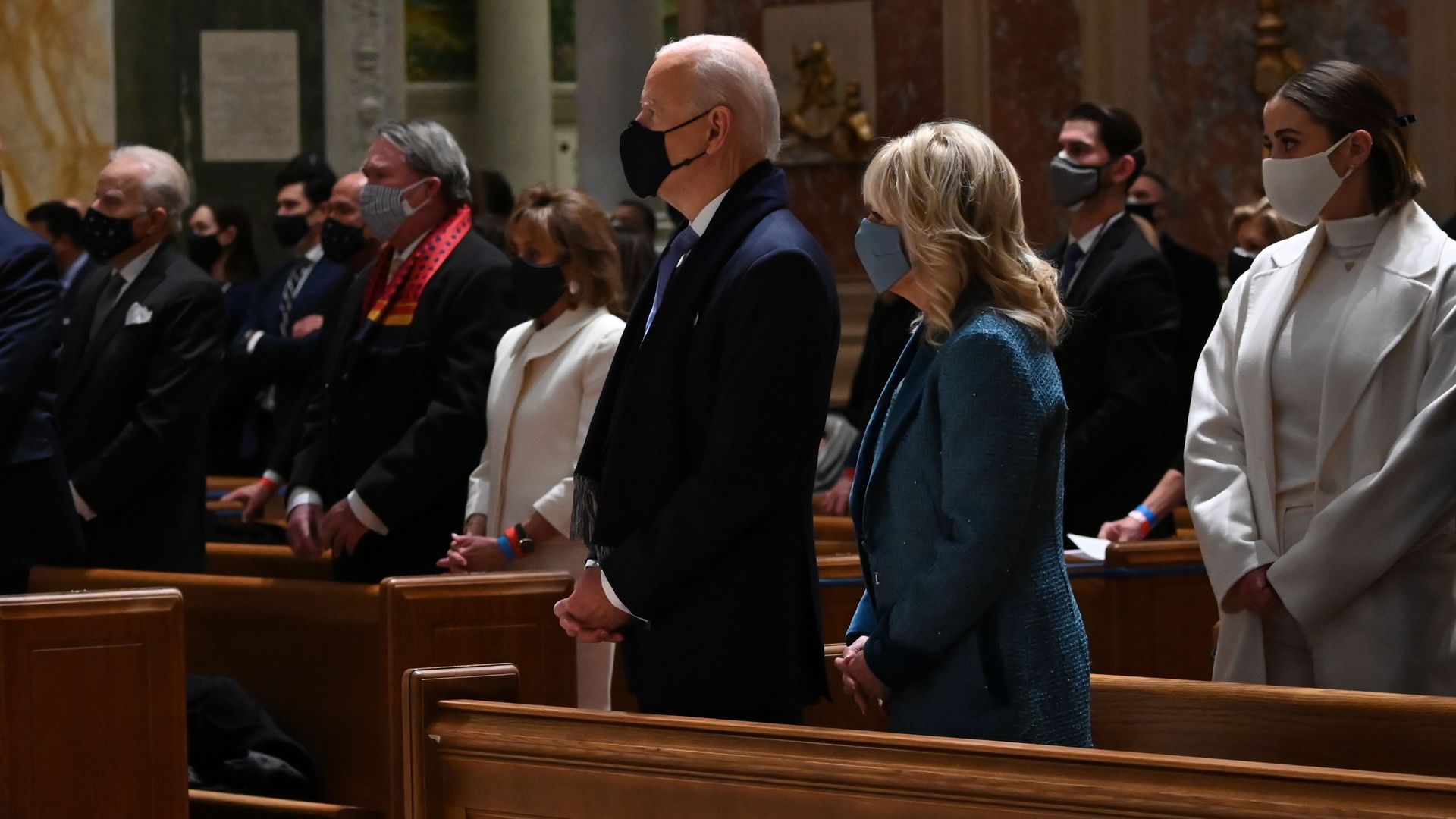 Joe Biden and Jill Biden stand next to each other in a church pew