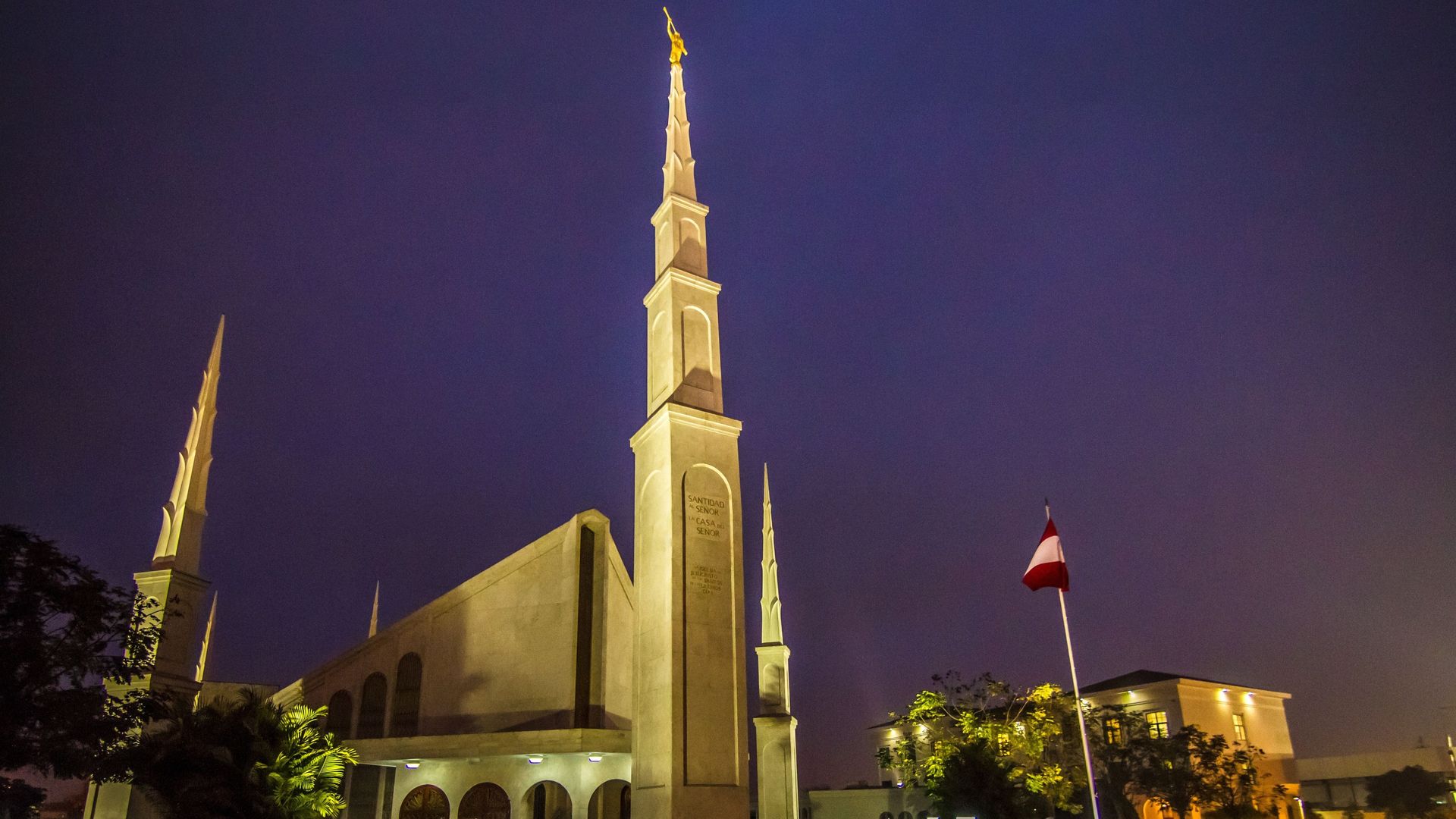A large church building lit from the outside in the evening. 