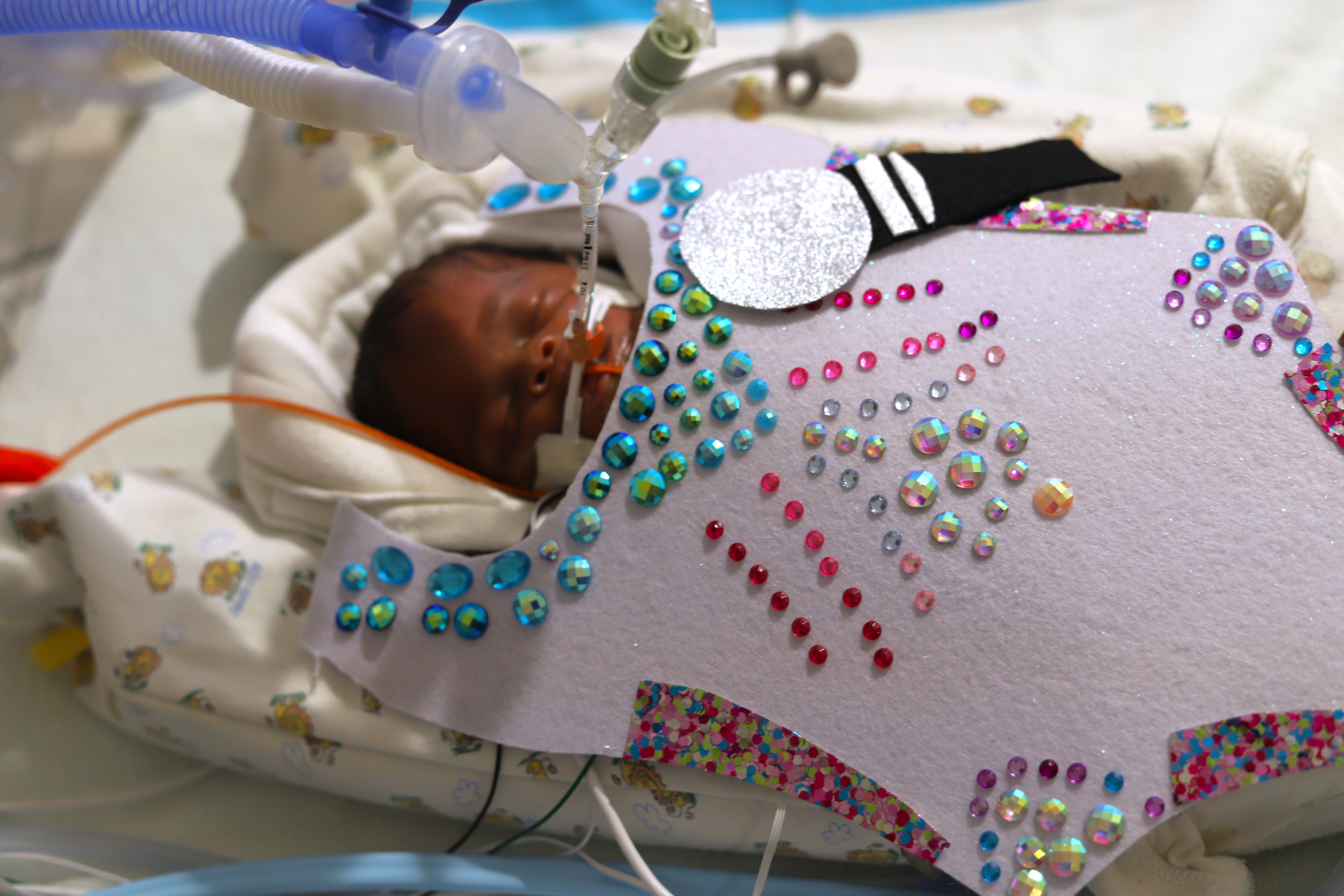 Photo shows a baby with a rhinestone costume for Taylor Swift.