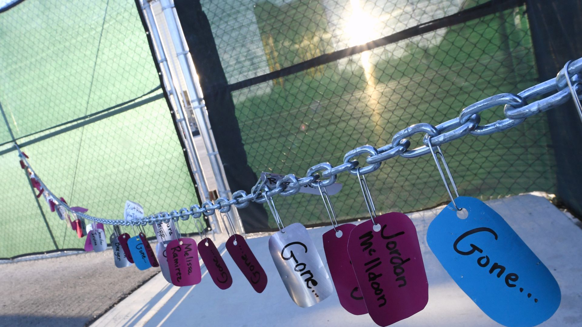Tags bearing the names of those killed in a massacre almost two years ago are attached to a chain-link fence with paper clips outside the Las Vegas Village