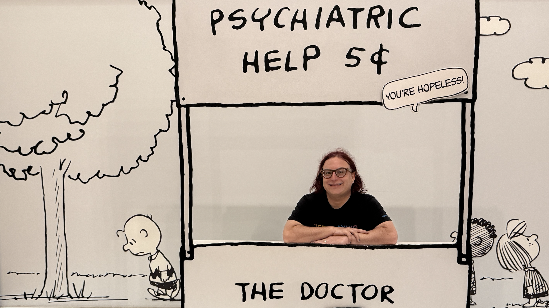 Axios' Ina Fried behind a life-size Peanuts cartoon that reads "Psychiatric Help: 5 cents" and "The doctor is in."