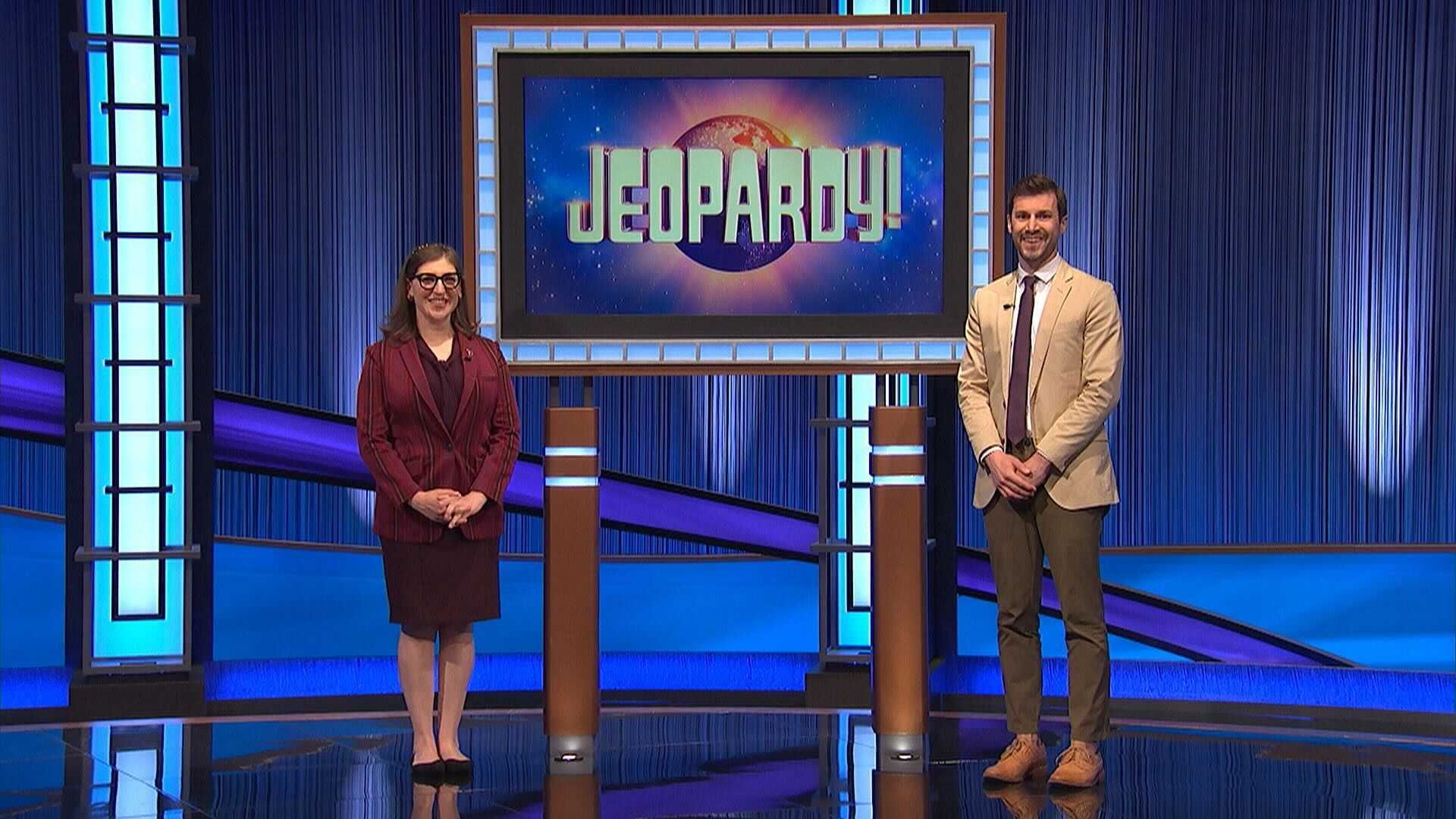 Two people on the Jeopardy! stage, smiling