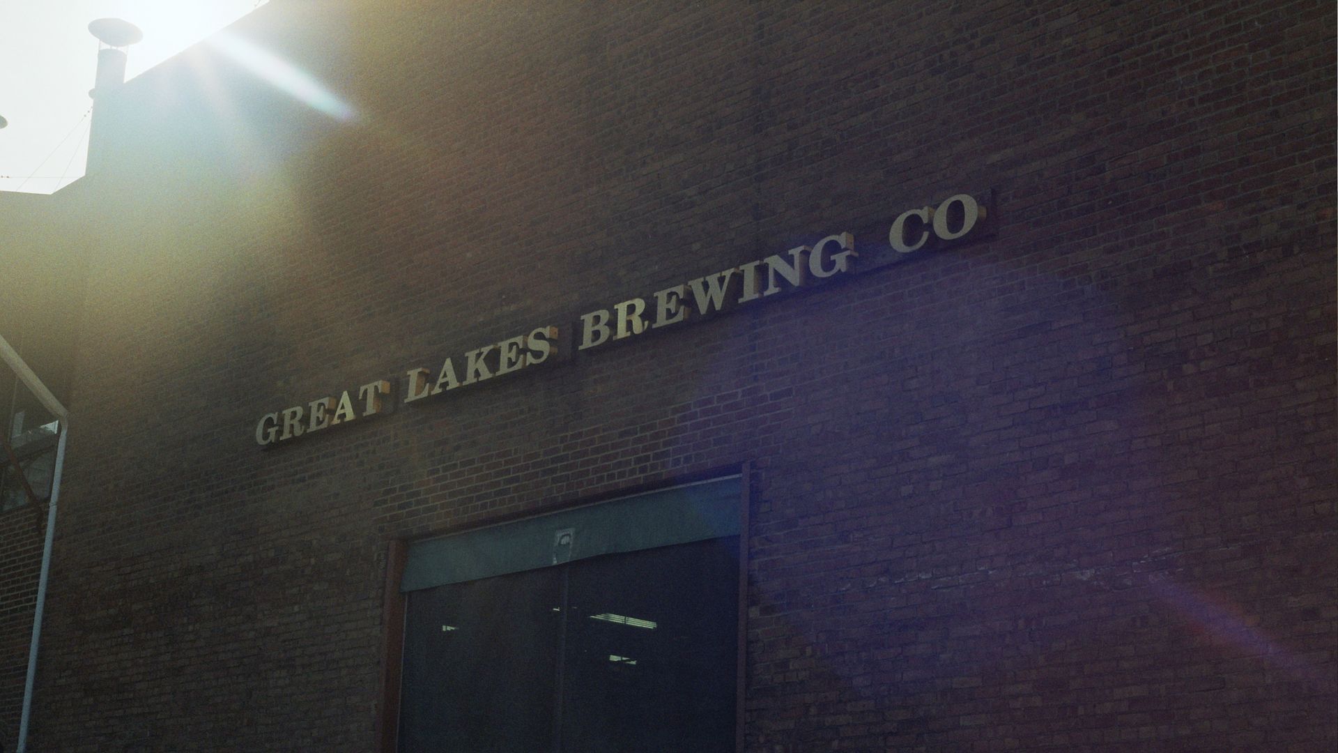 Exterior photo of Great Lakes Brewing Co.'s brick production facility, with sunlight cascading