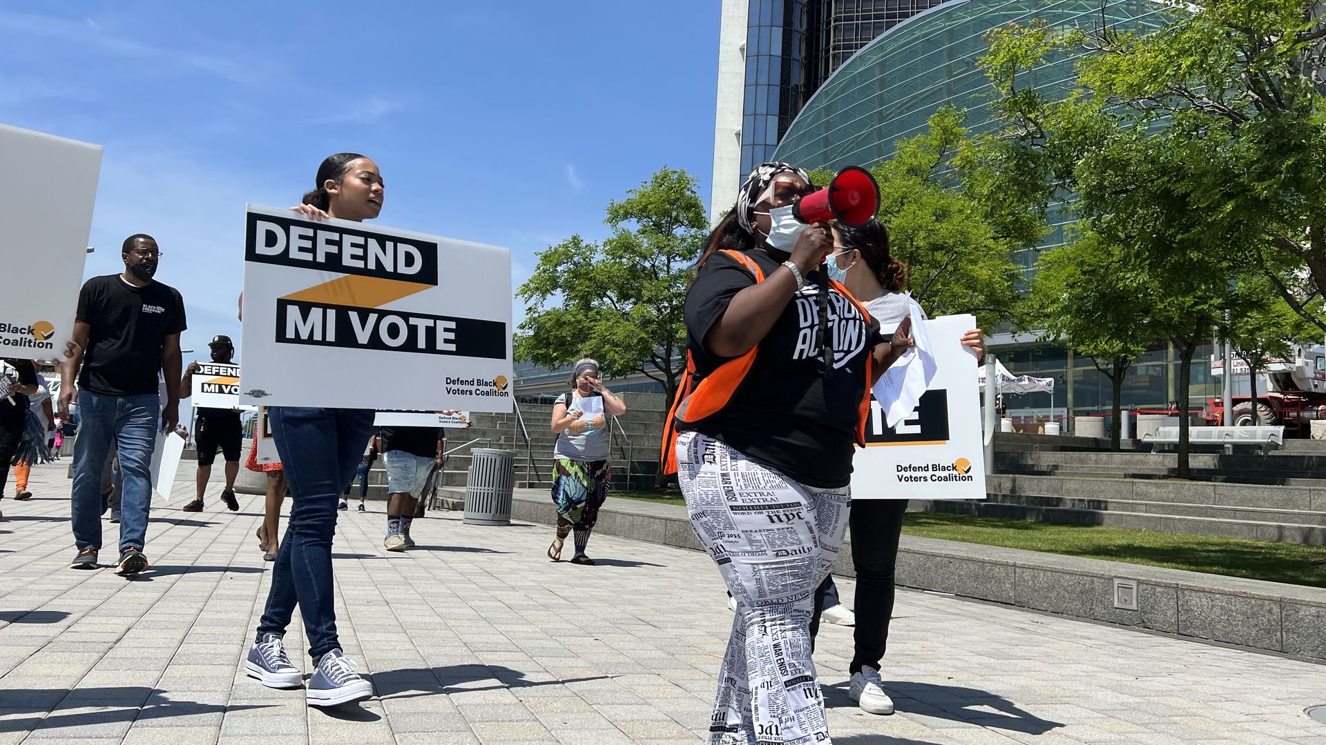 Activists march outside the Renaissance Center