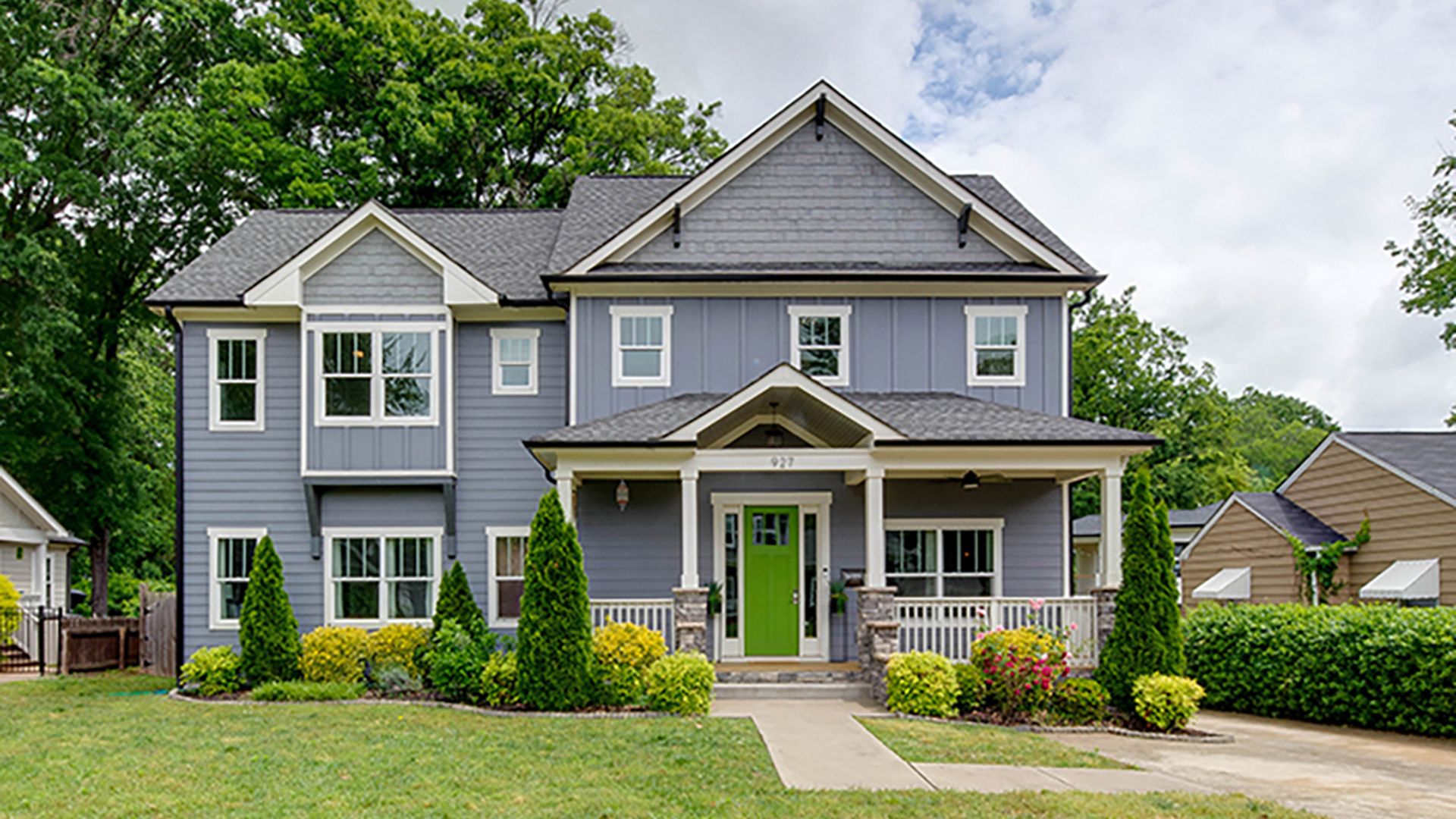 Gray, two-story home with a lime green door