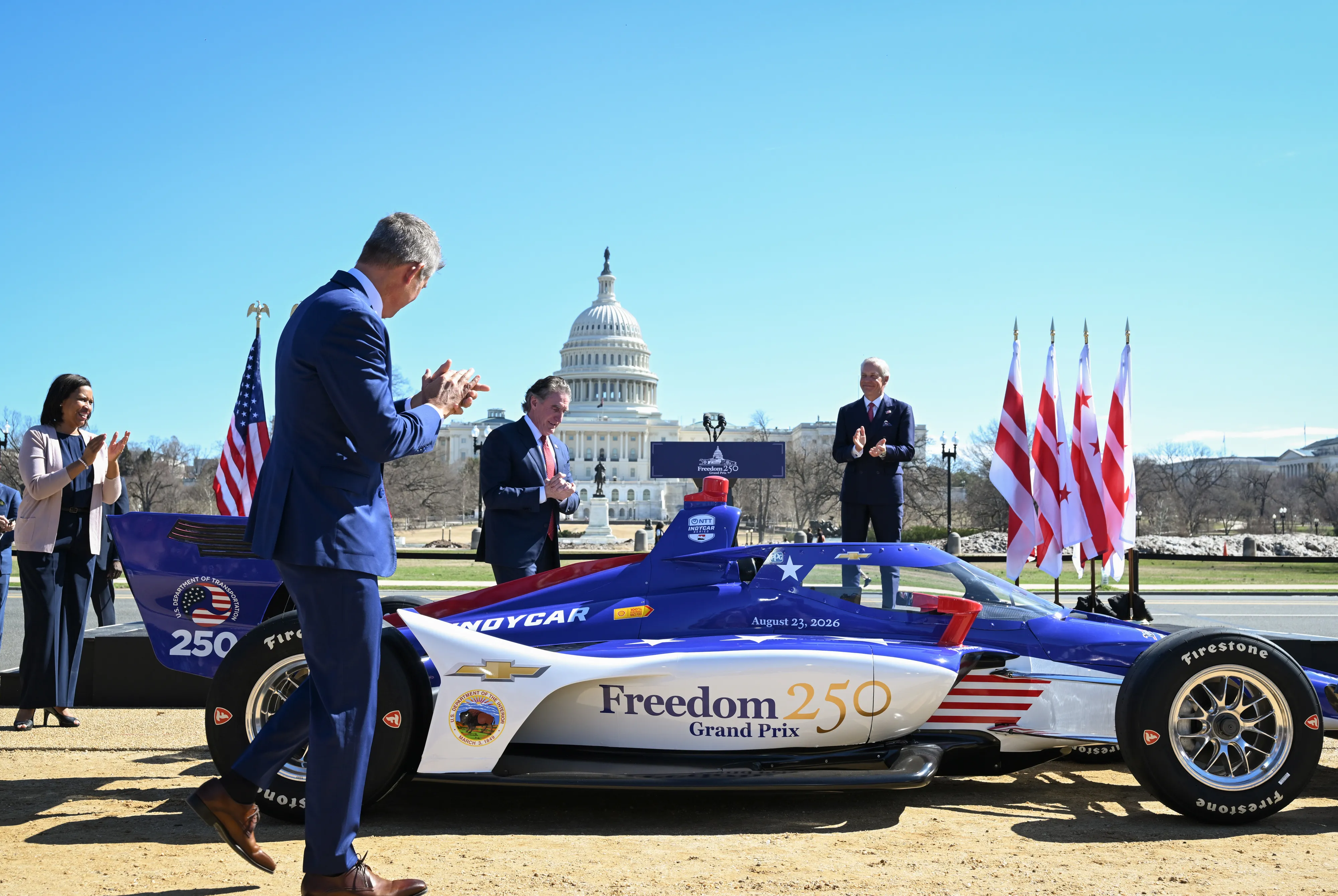 D.C. Mayor Muriel Bowser, Transportation Secretary Sean Duffy and Interior Secretary Doug Burgum unveil a custom red, white and blue IndyCar in front of the Capitol yesterday. 