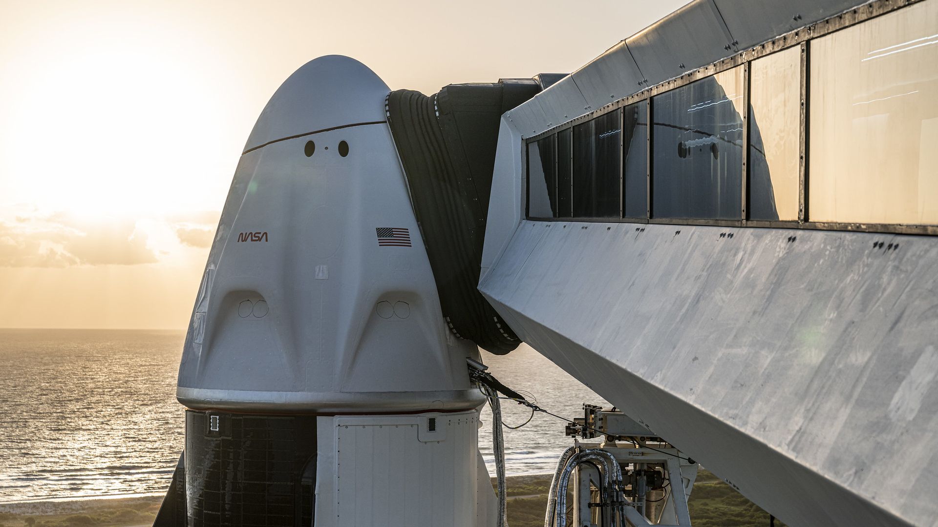 SpaceX's Crew-4 spacecraft awaiting launch with the sunrise in the distance.