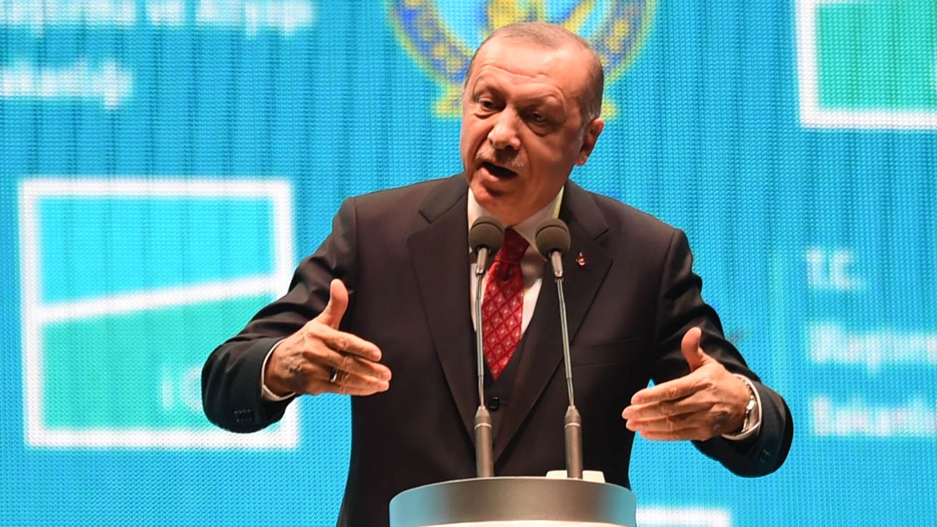 President Erdogan speaking at a podium.