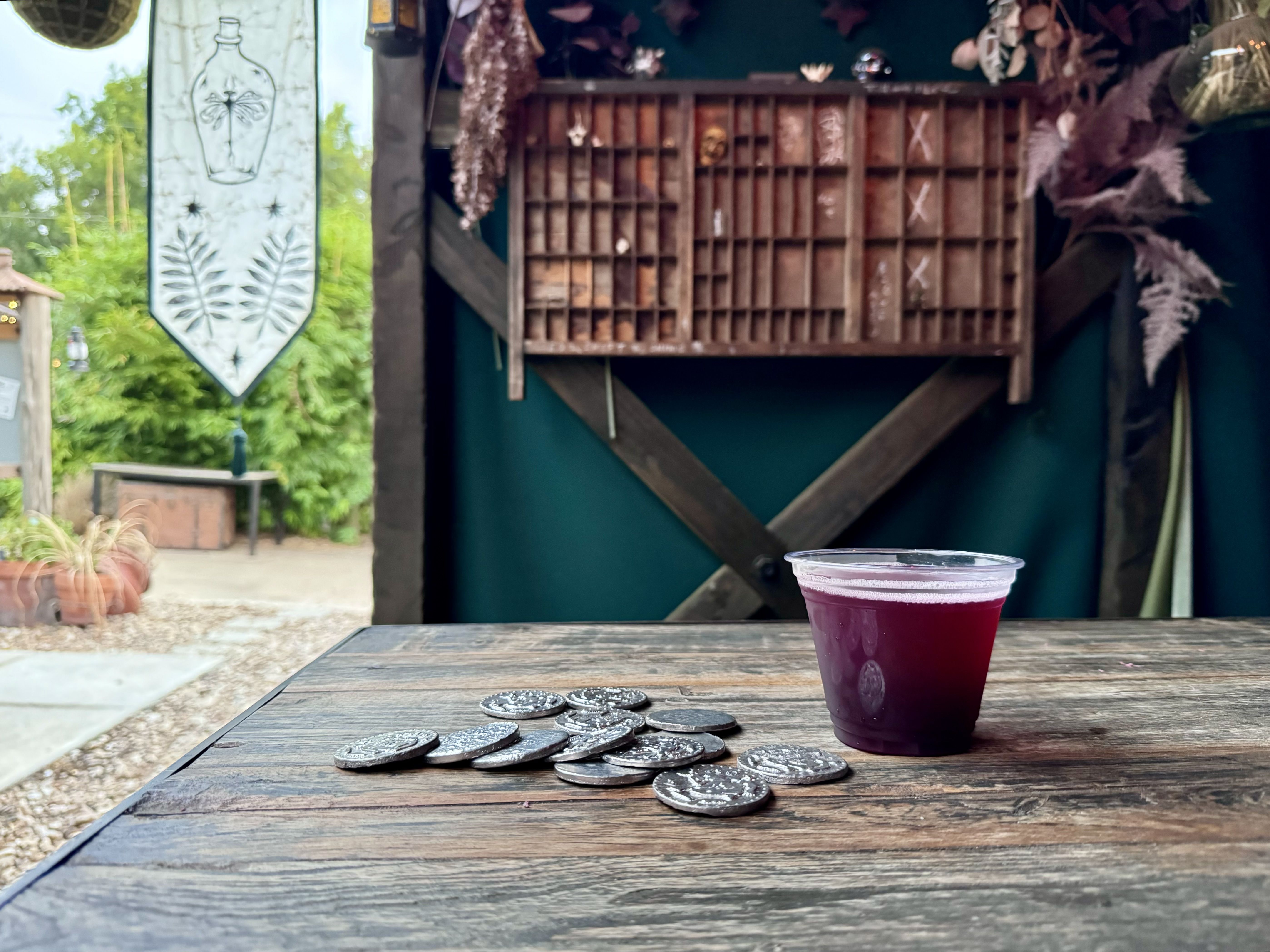 A photo of a drink and coins on a table.