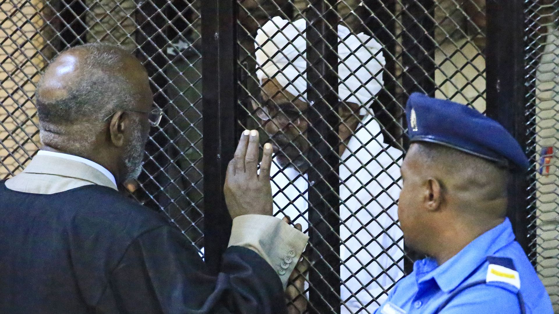 Sudan's deposed military president Omar al-Bashir sits in a defendant's cage
