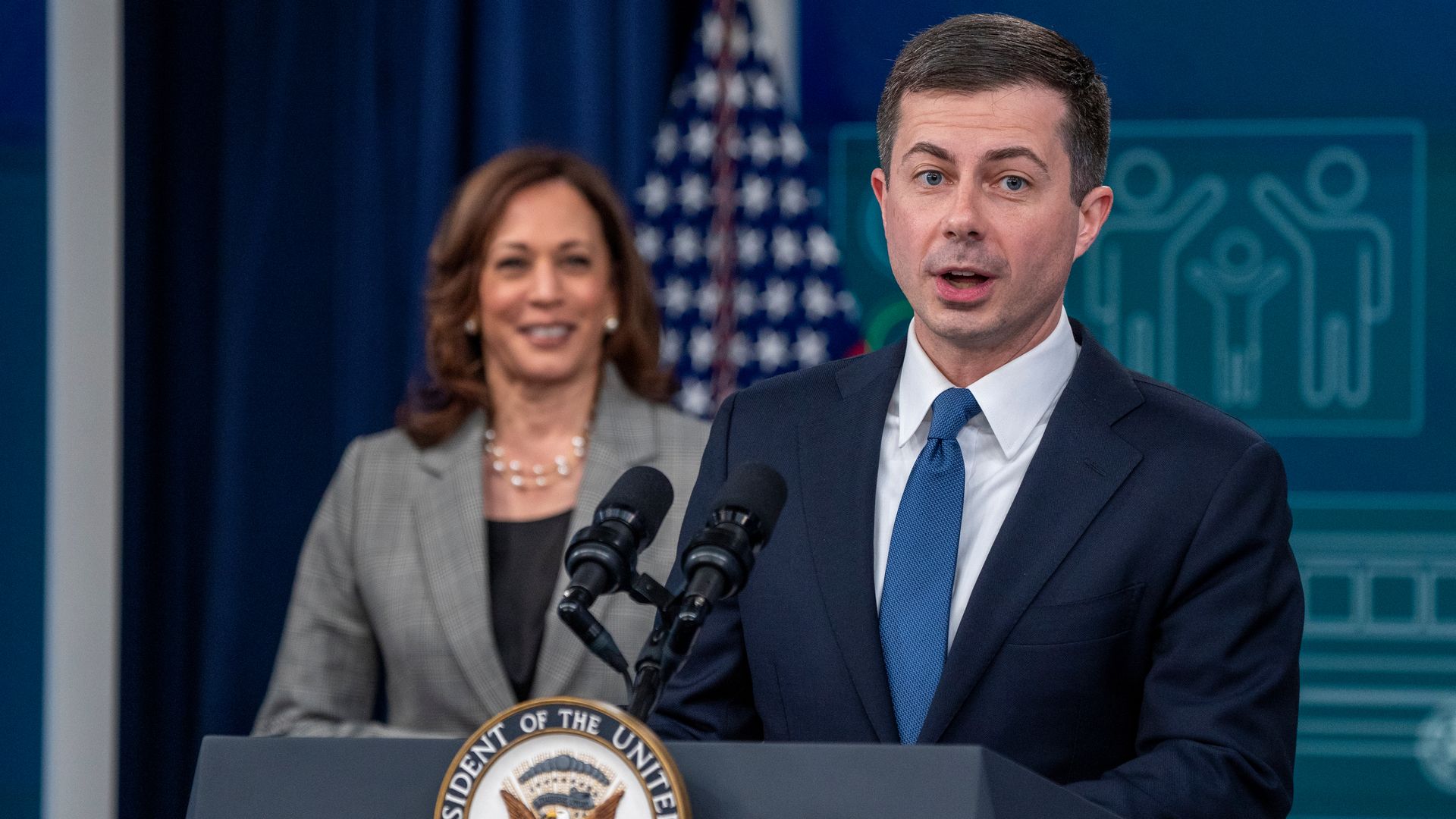 Vice President Kamala Harris is seen looking on as Transportation Secretary Pete Buttigieg speaks at an event on Monday.