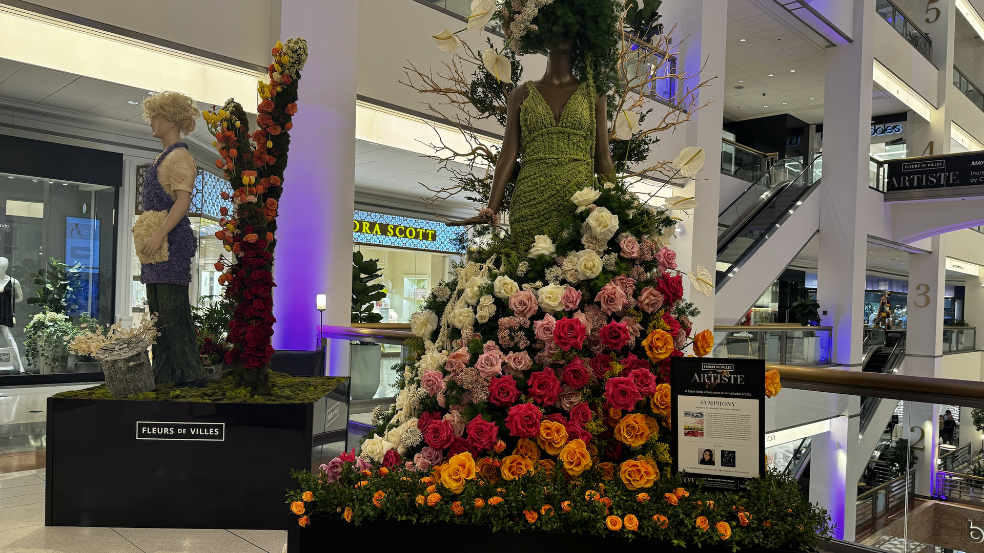 Photo of mannequins at a mall covered in flowers 