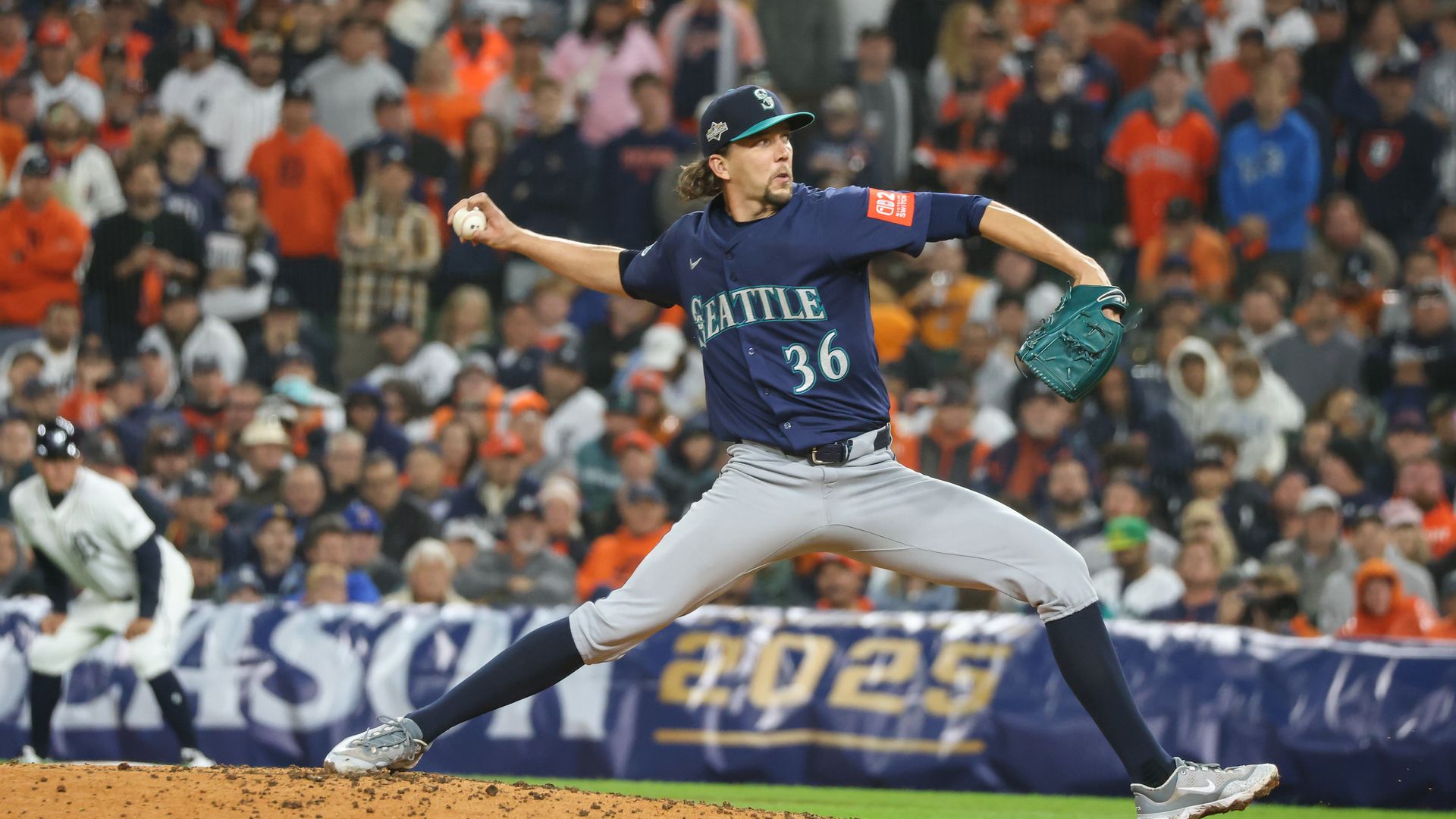 A baseball pitcher's body stretches in a wind up as he prepares to throw. 