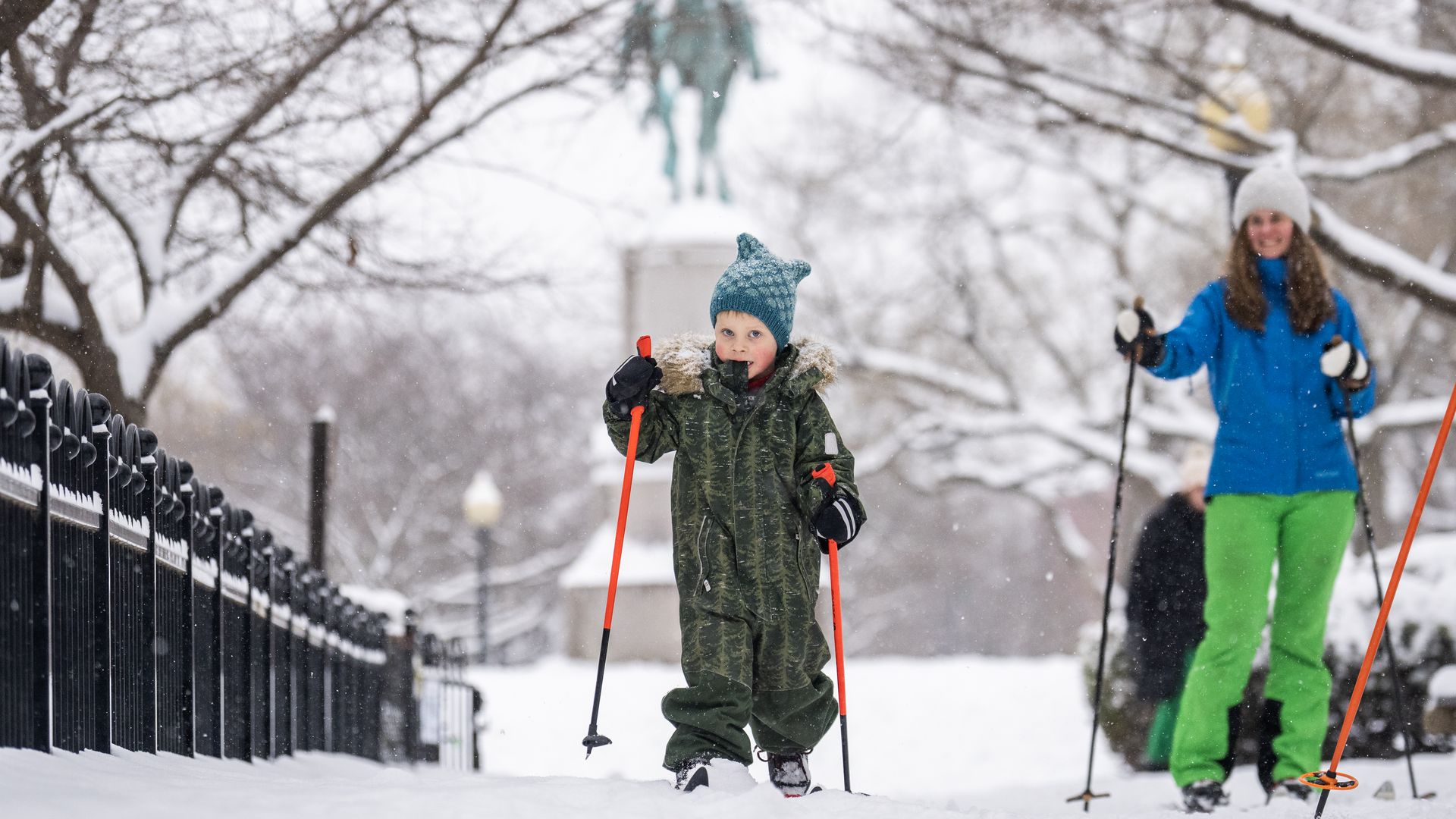 A child on skis in a snow covered park