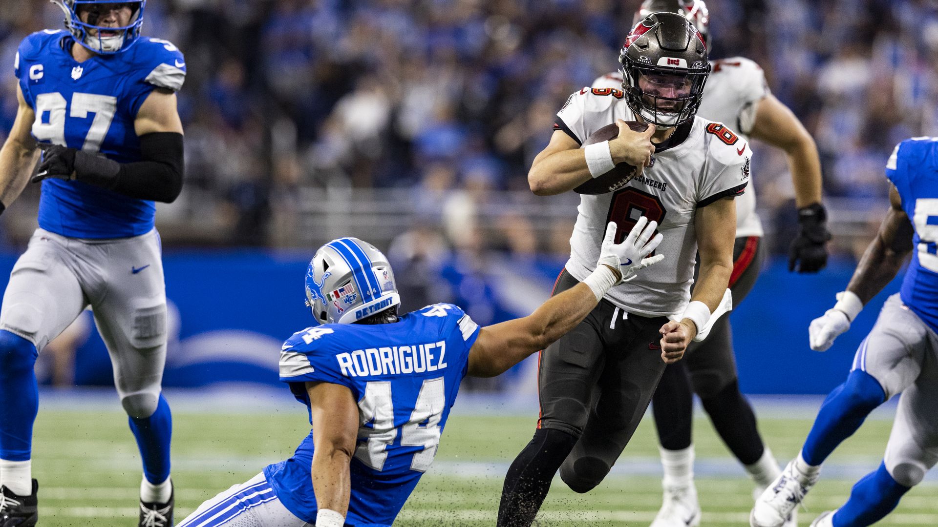 The Lions' Malcolm Rodriguez tries to tackle Bucs quarterback Baker Mayfield at Ford Field yesterday. 
