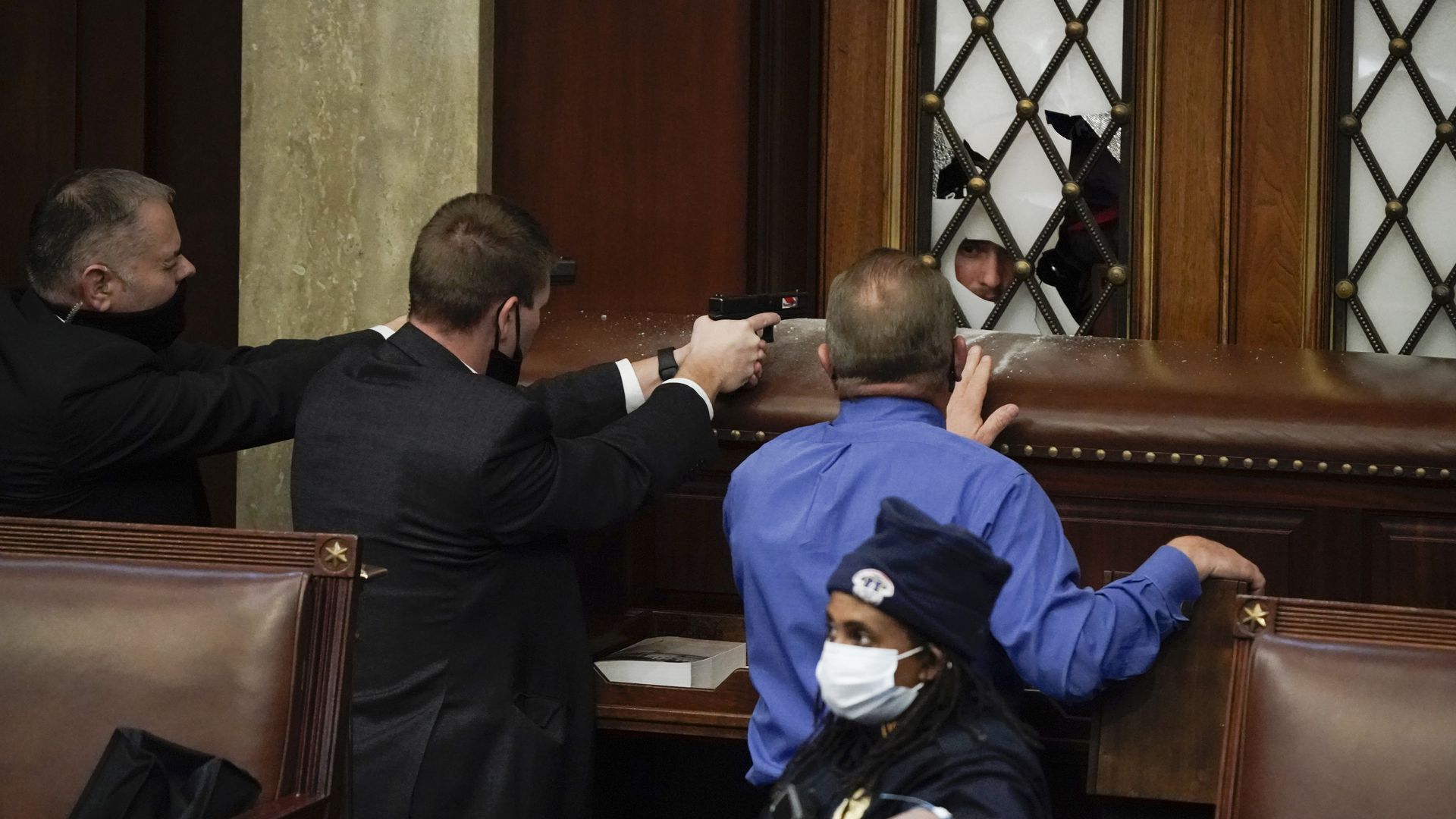 Capitol Police, with guns drawn, guard the doors to House chambers in the U.S. Capitol.