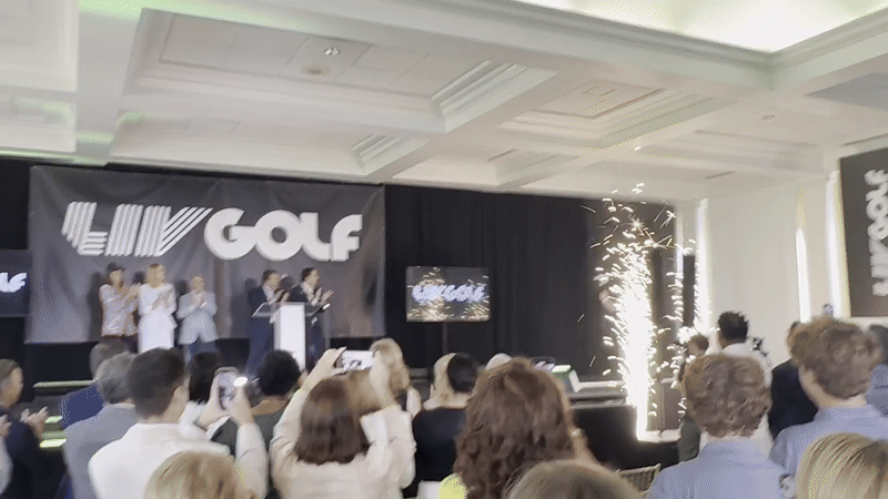 Image shows Jeff Landry walking on stage with sparklers going. The sign says LIV Golf.