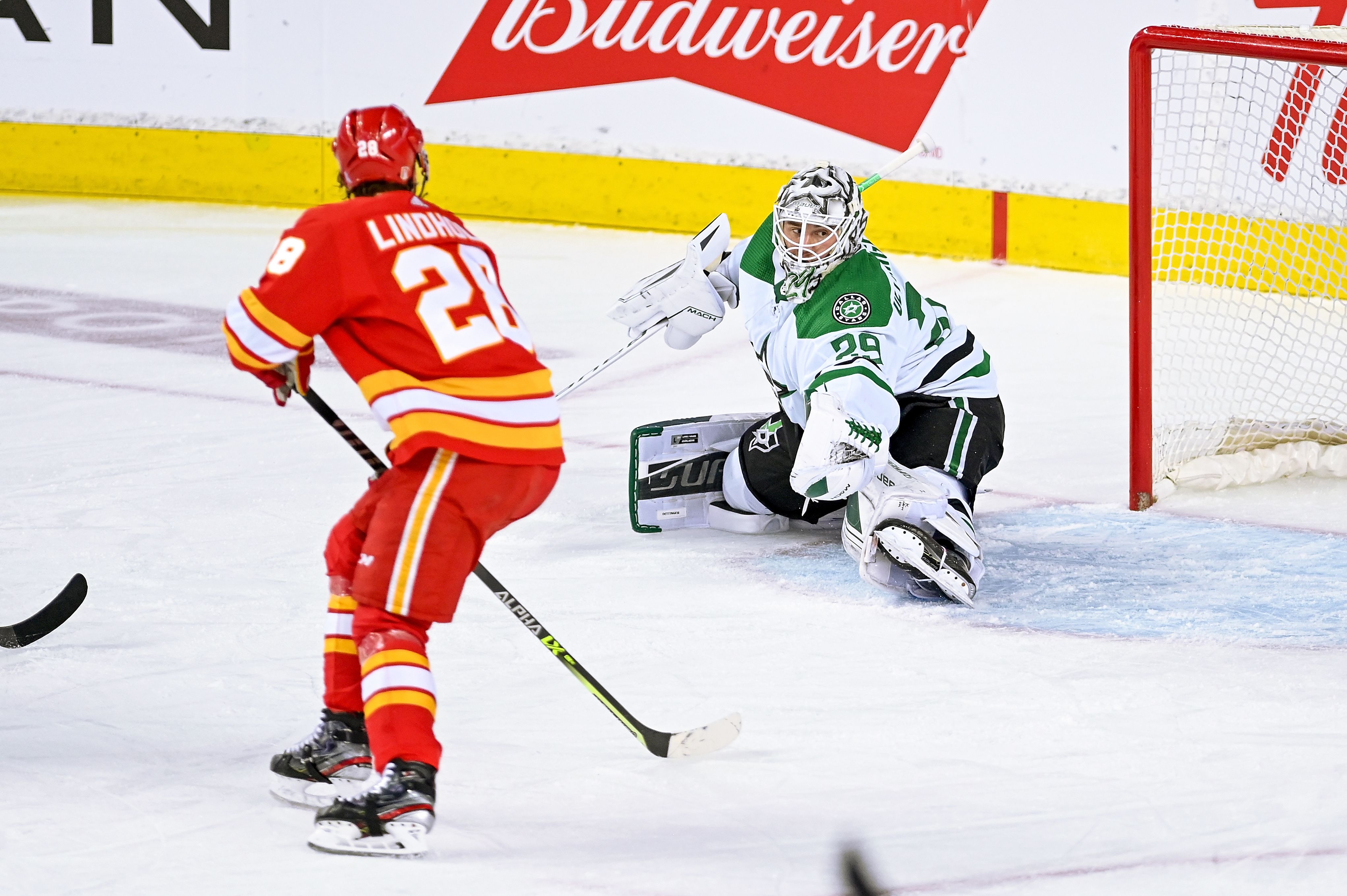 A Calgary player near the Dallas goal and the Dallas goalie sprawled out