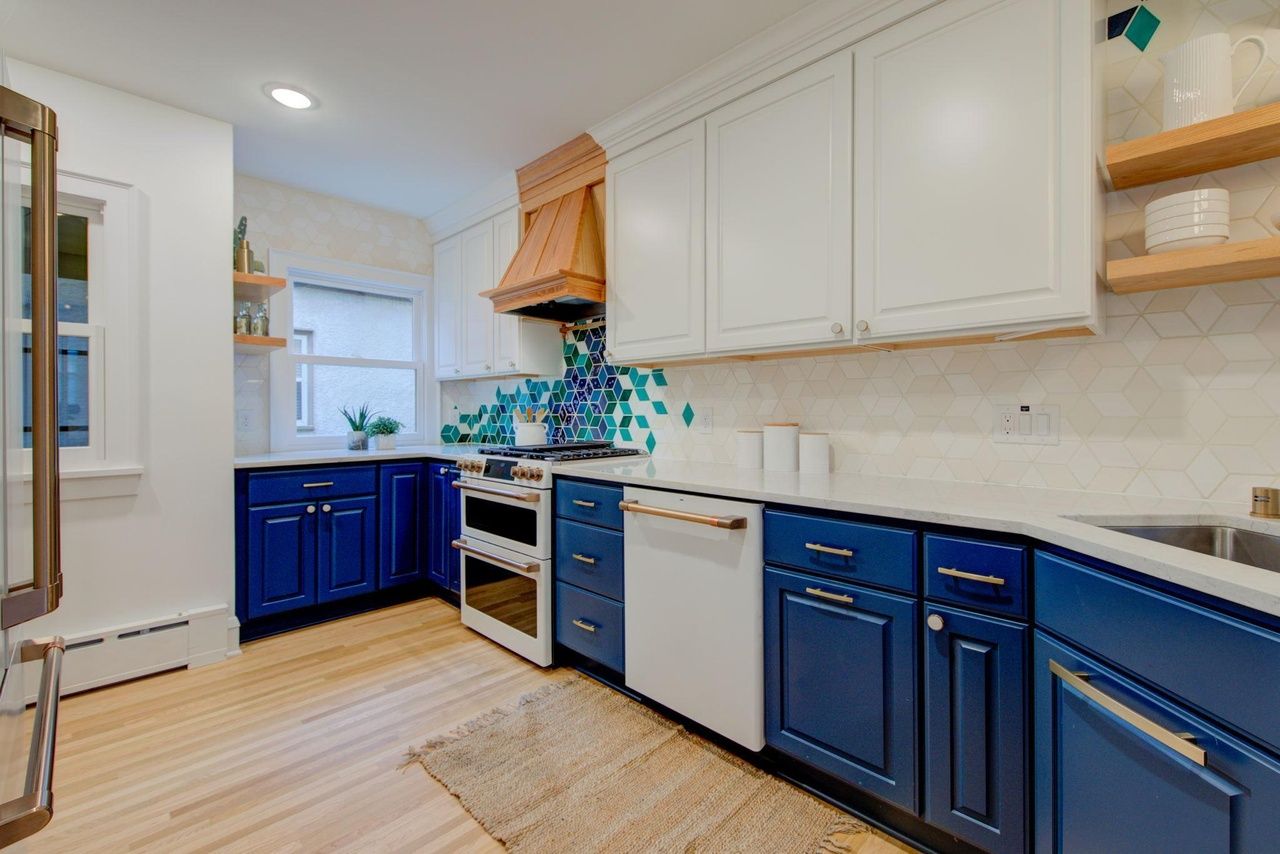 custom kitchen with blue cabinets and white matte appliances and tile mosaic