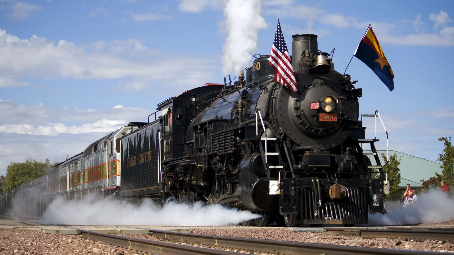 A steam locomotive with Arizona and American flags.