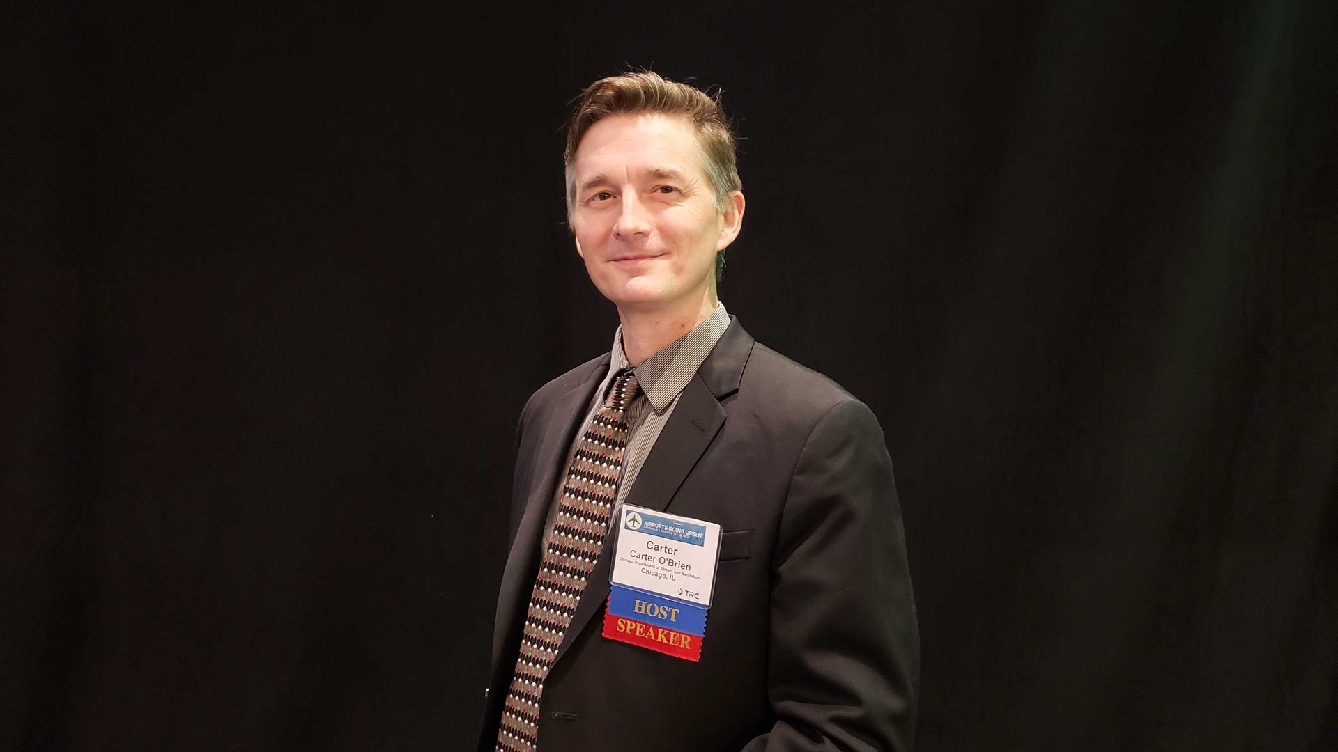 Guy holding a coffee cup and wearing a suit 