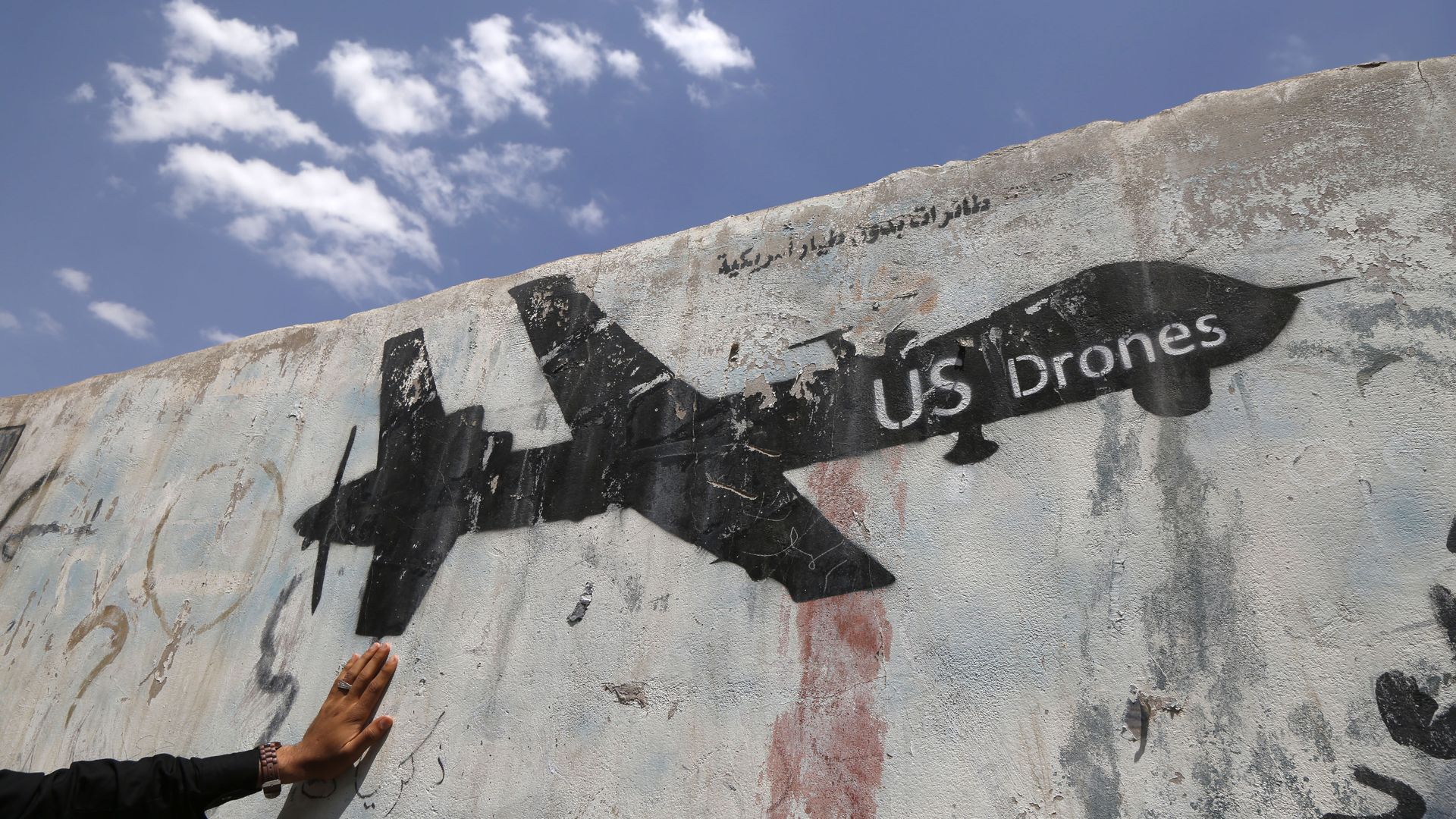 A Yemeni man looks at graffiti protesting against US drone strikes on September 19, 2018 in Sana'a, Yemen.