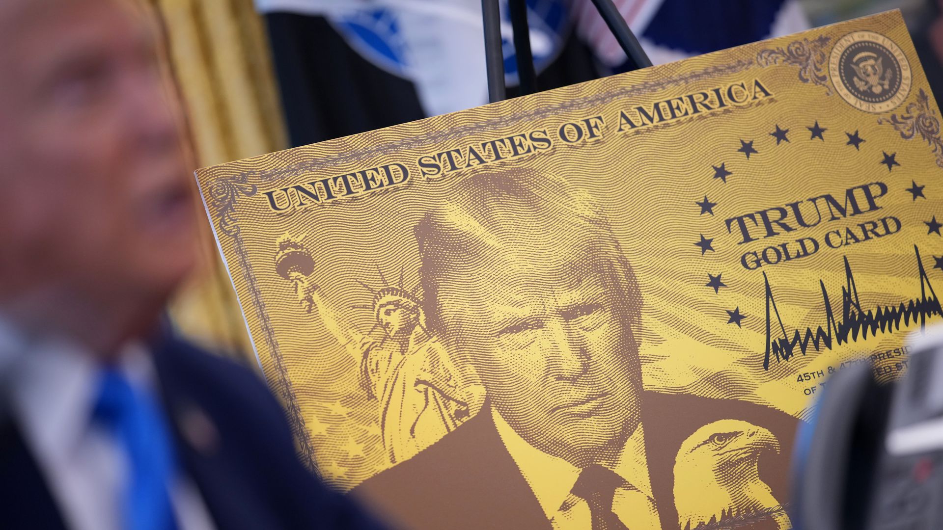 A poster in gold colors with a picture of President Trump and the words Trump Gold Card. 