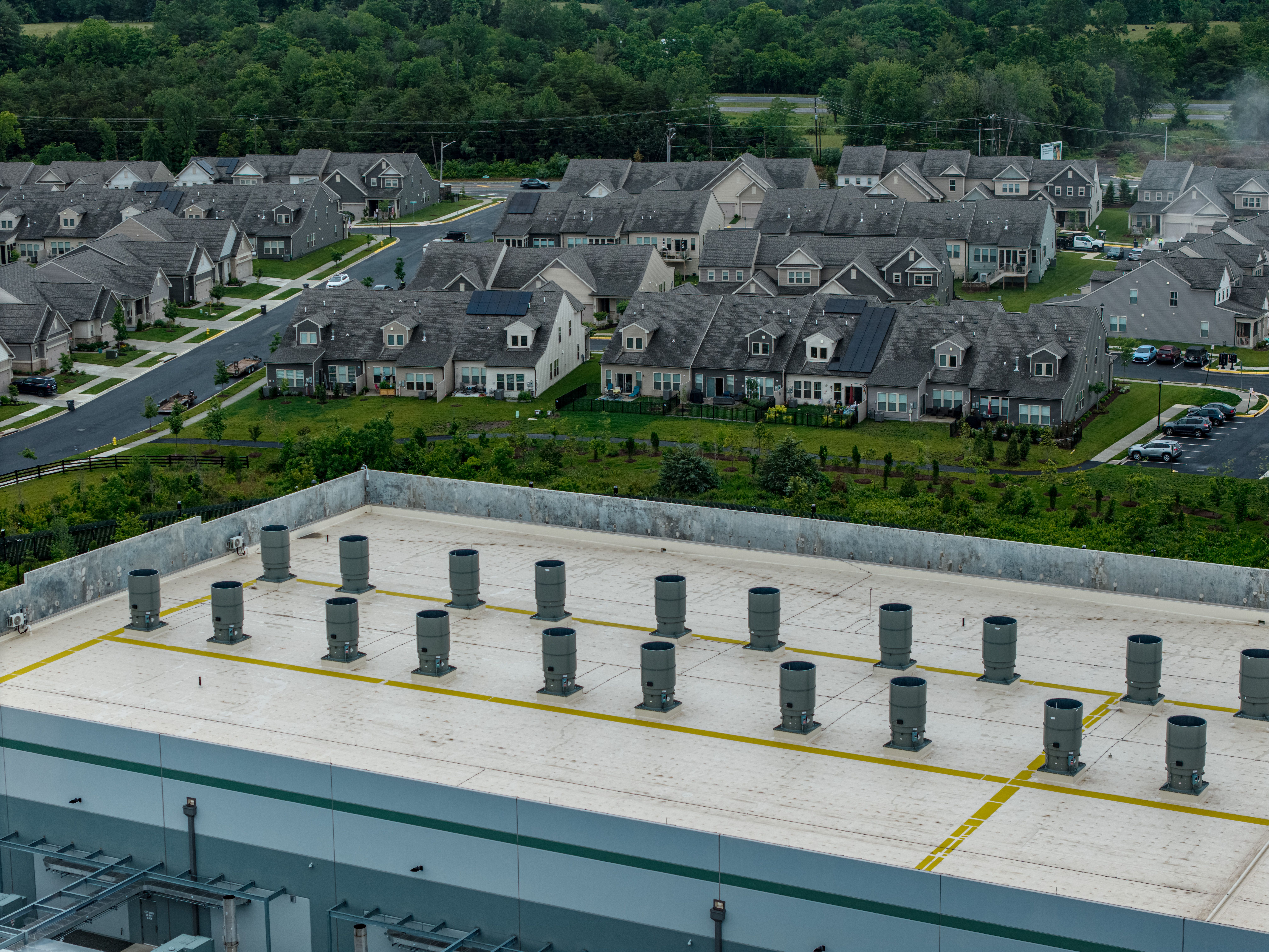 The roof of a data center with homes in the background.
