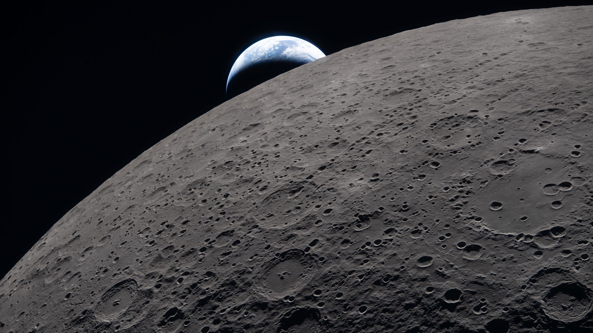 Cratered lunar surface curves across the foreground, with Earth rising over the horizon in the dark space, showing blue oceans and white clouds.