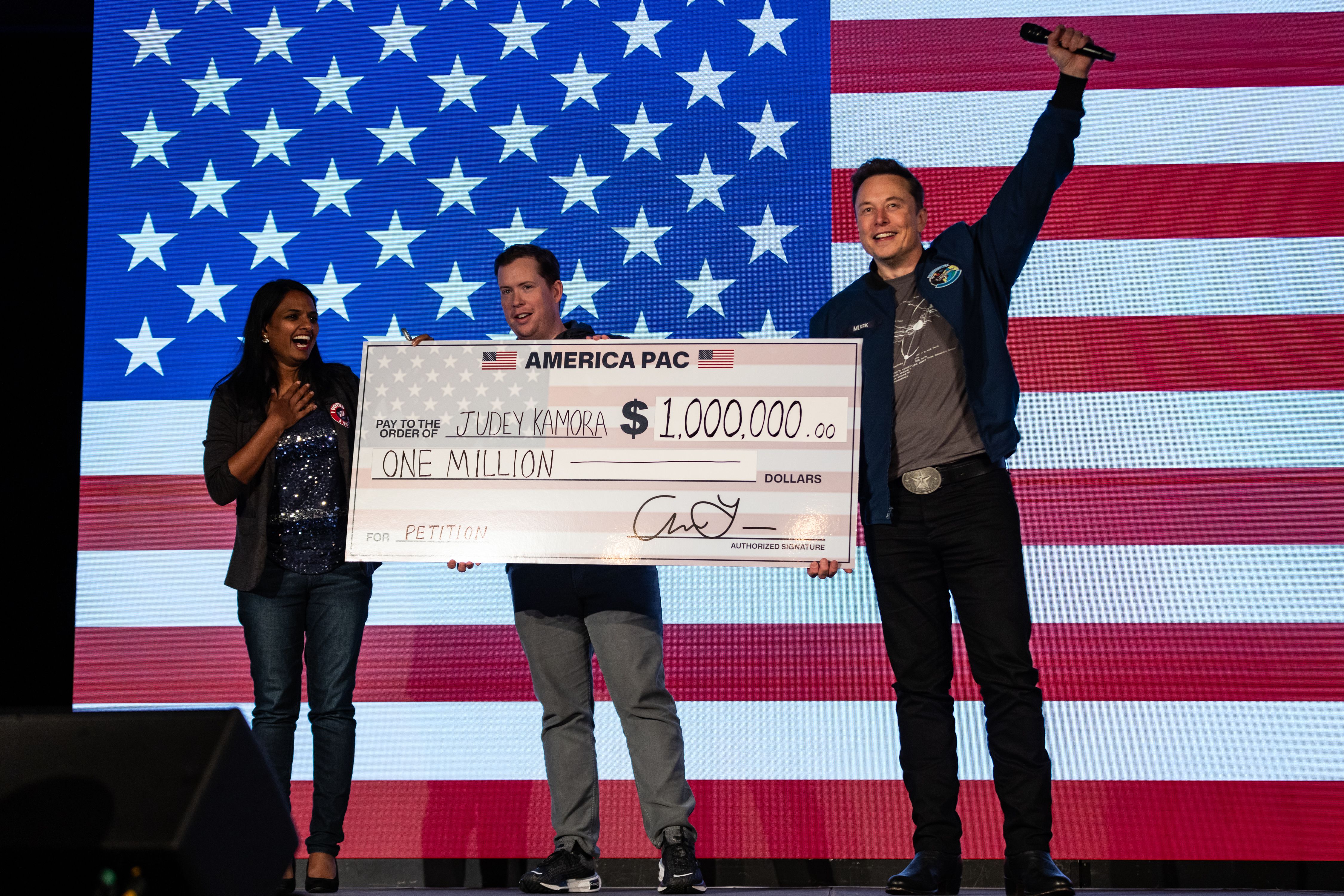 LANCASTER, PENNSYLVANIA - OCTOBER 26: SpaceX and Tesla founder Elon Musk awards Judey Kamora with $1,000,000 during an America PAC town hall on October 26, 2024 in Lancaster, Pennsylvania. Musk has donated more than $75 million to America PAC, which he co-founded with fellow Silicon Valley venture c