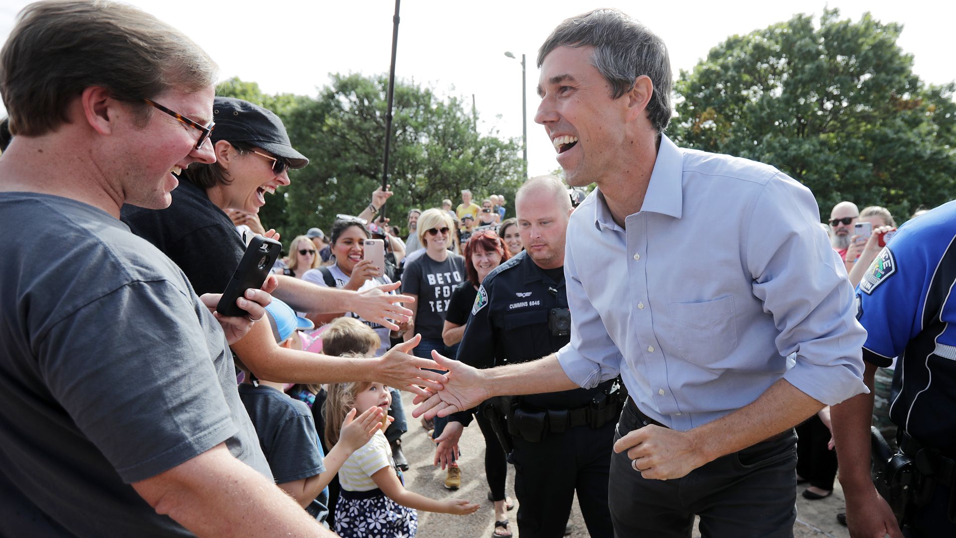 Beto O'Rourke high fives with supporters.